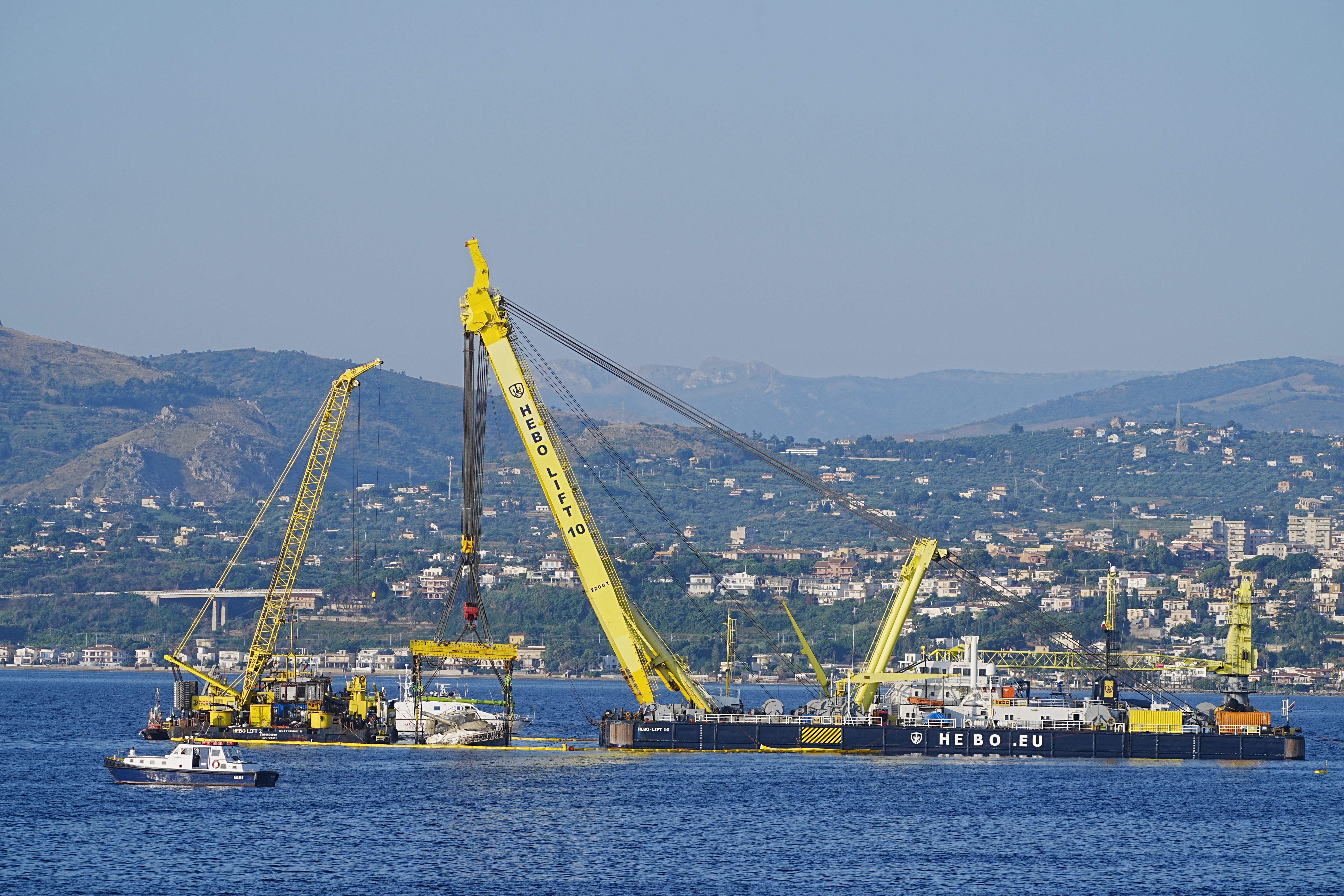 The 56-metre (184ft) vessel was spotted in an upright position near the fishing town of Porticello on Saturday morning, held by one of Europe’s most powerful sea cranes