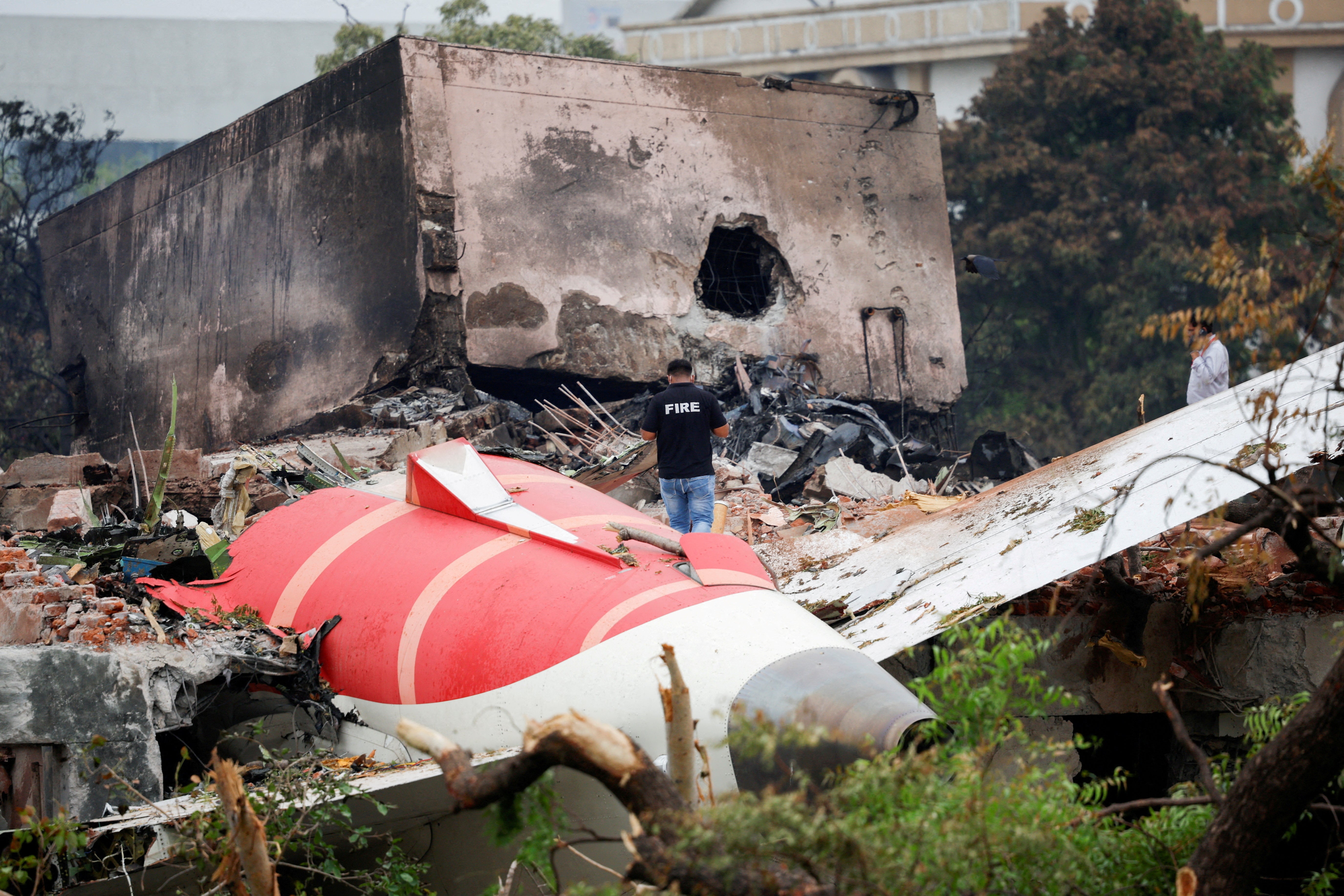 A fire officer stands next to the crashed Air India Dreamliner aircraft in Ahmedabad, India, on 13 June 2025