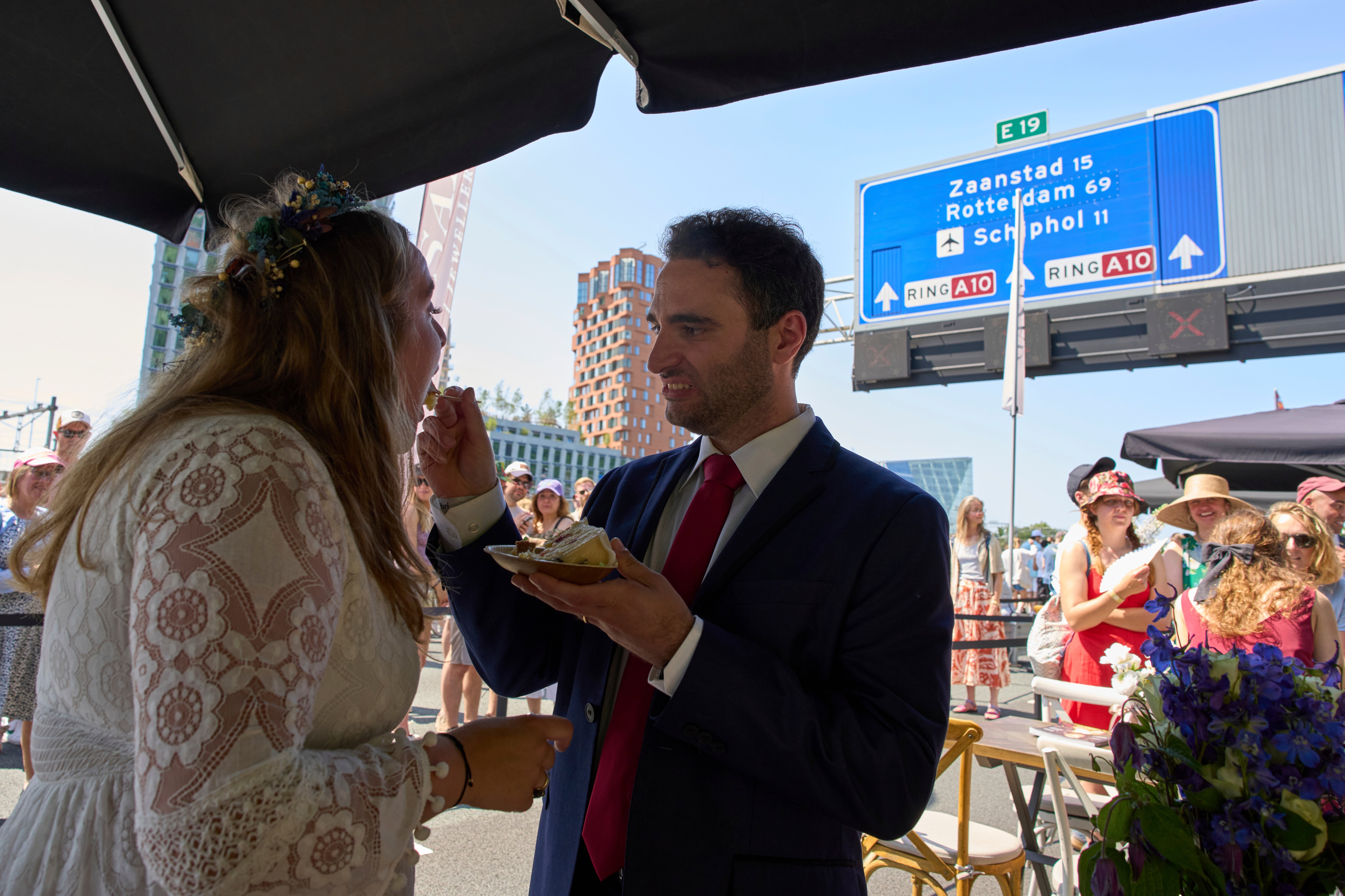 Zuzana Lisowska and Yuri Iozzelli get married on a highway bypass, as the Dutch capital celebrates its 750th anniversary with weddings, music and other events on the A10 ring road in Amsterdam, Netherlands, Saturday, June 21, 2025. (AP Photo/Peter Dejong)