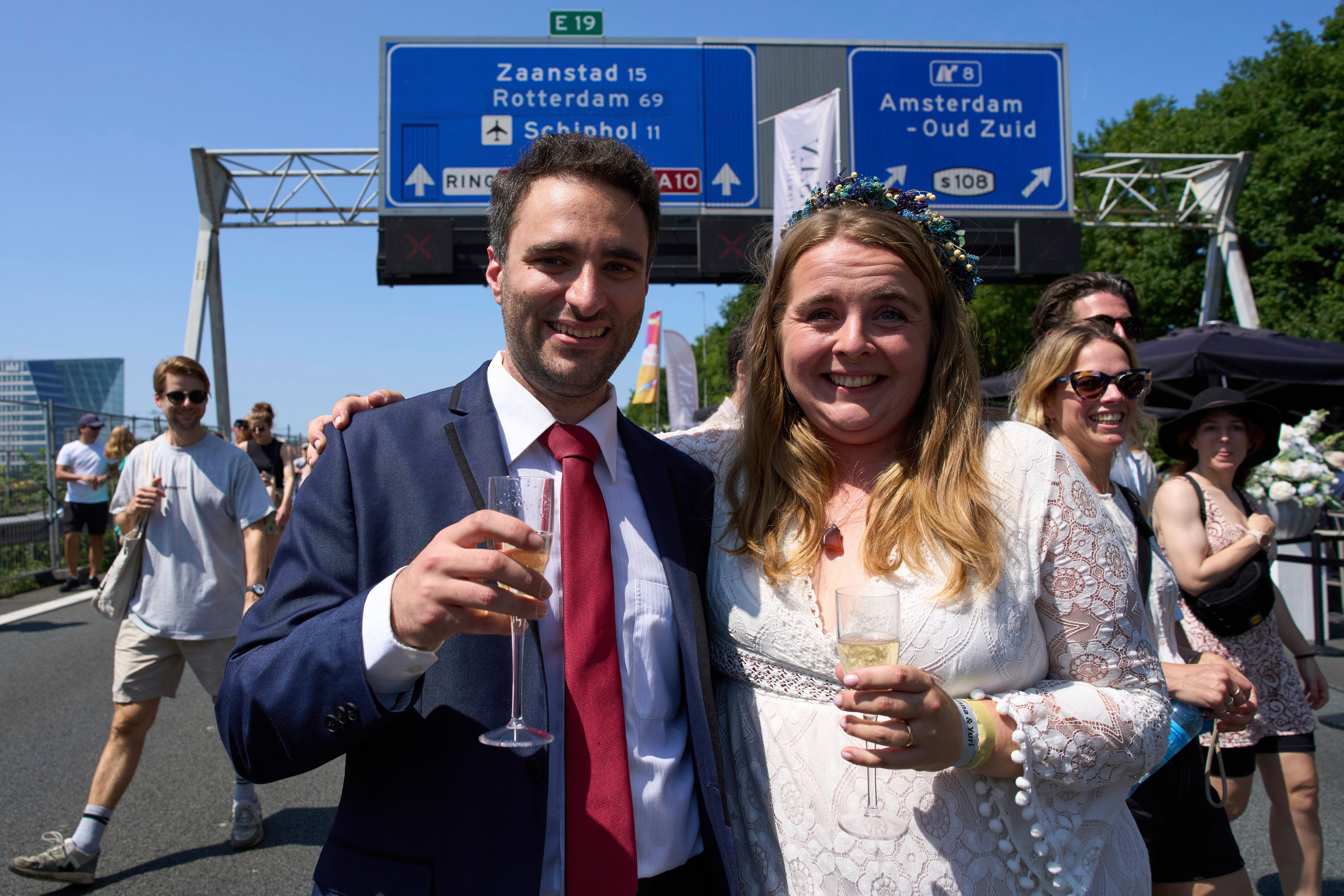 Zuzana Lisowska and Yuri Iozzelli celebrate after getting married on a highway bypass as the Dutch capital celebrates its 750th anniversary with weddings, music and other events on the A10 ring road in Amsterdam, Netherlands, Saturday, June 21, 2025. (AP Photo/Peter Dejong)