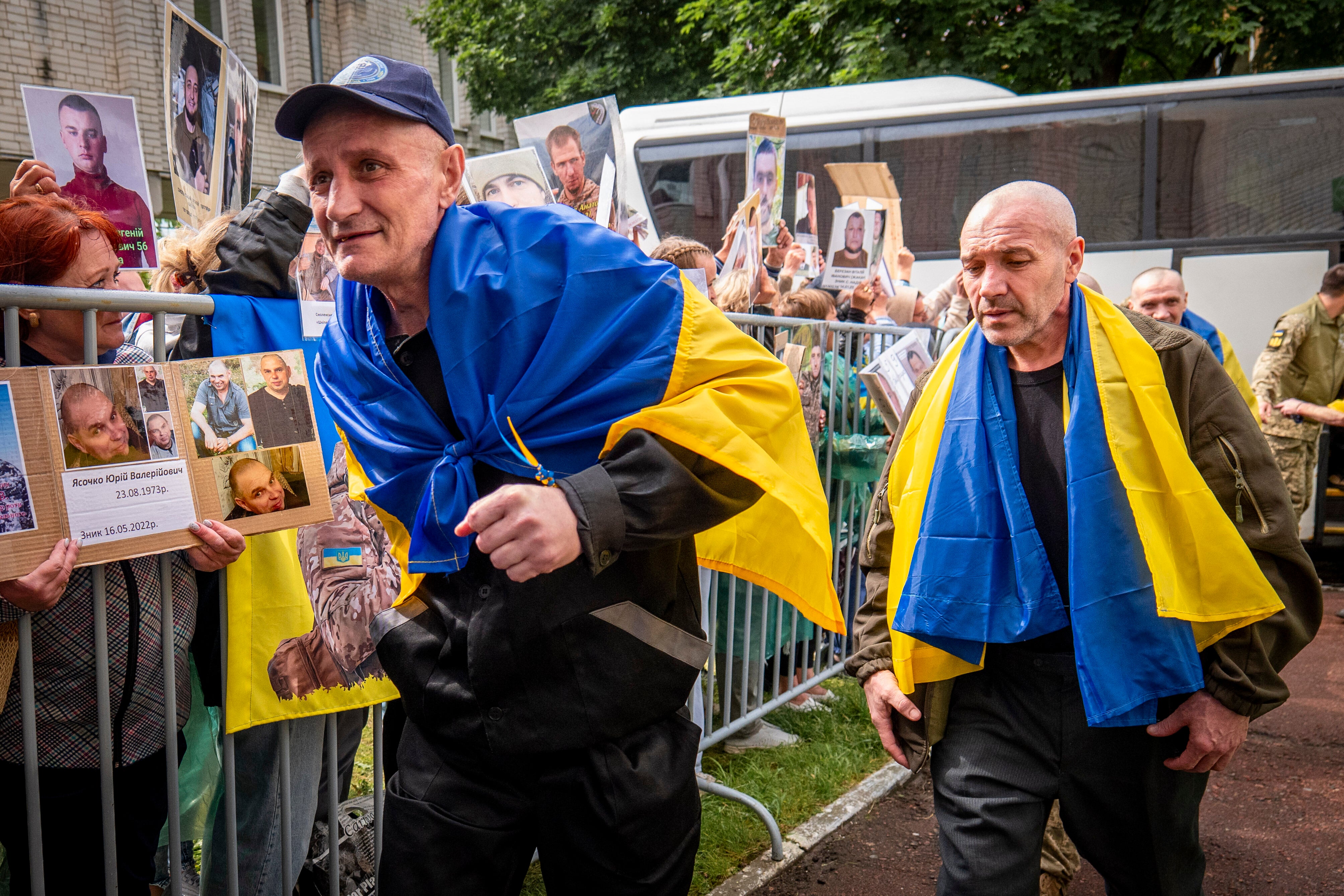 Freed Ukrainian soldiers arriving after a POW exchange with Russia walk past Ukrainians holding photos of their missing relatives in the Chernyhiv region, Ukraine, Friday, June 20, 2025. (AP Photo/Dan Bashakov)