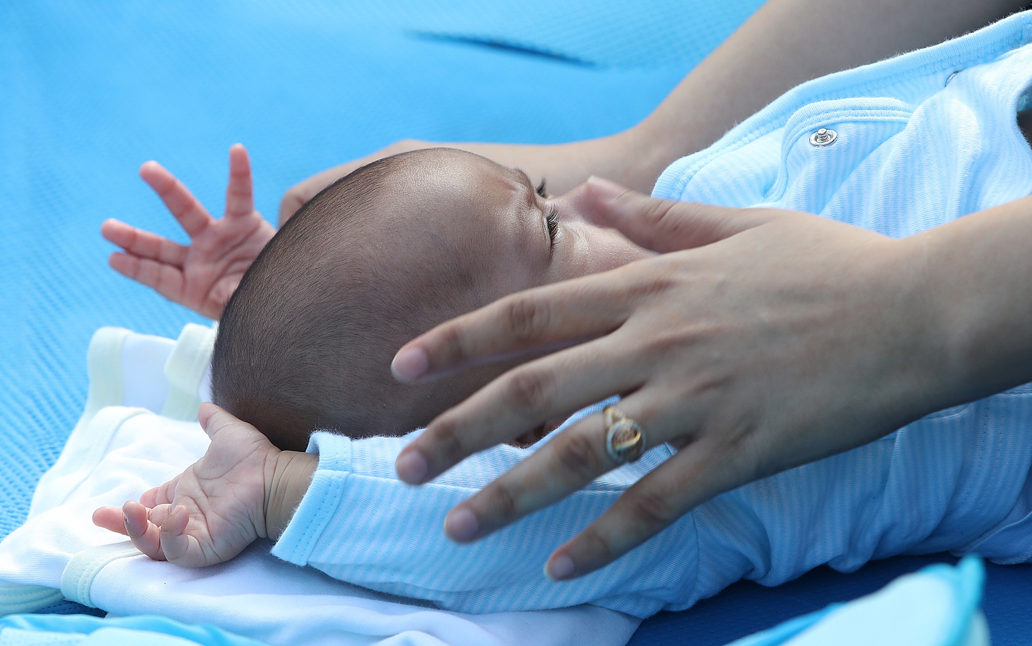 A mother performs yoga with her infant in Lodhi Gardens, in New Delhi