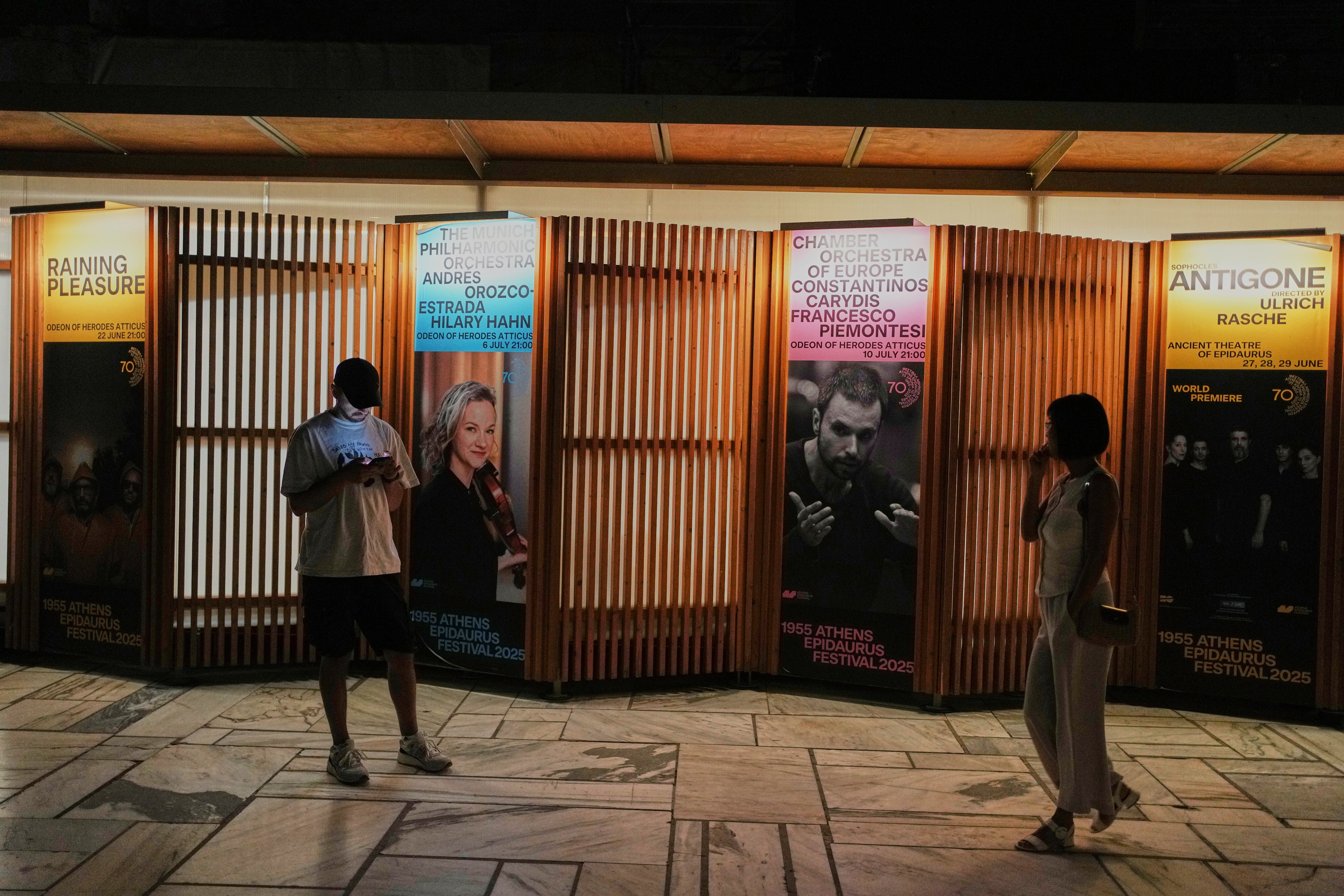 People walk outside the Odeon of Herodes Atticus during Giacomo Puccini's "Turandot" performance by the Greek National Opera part of the 70th Athens Epidaurus Festival in Athens, Greece, Tuesday, June 3, 2025. (AP Photo/Thanassis Stavrakis)