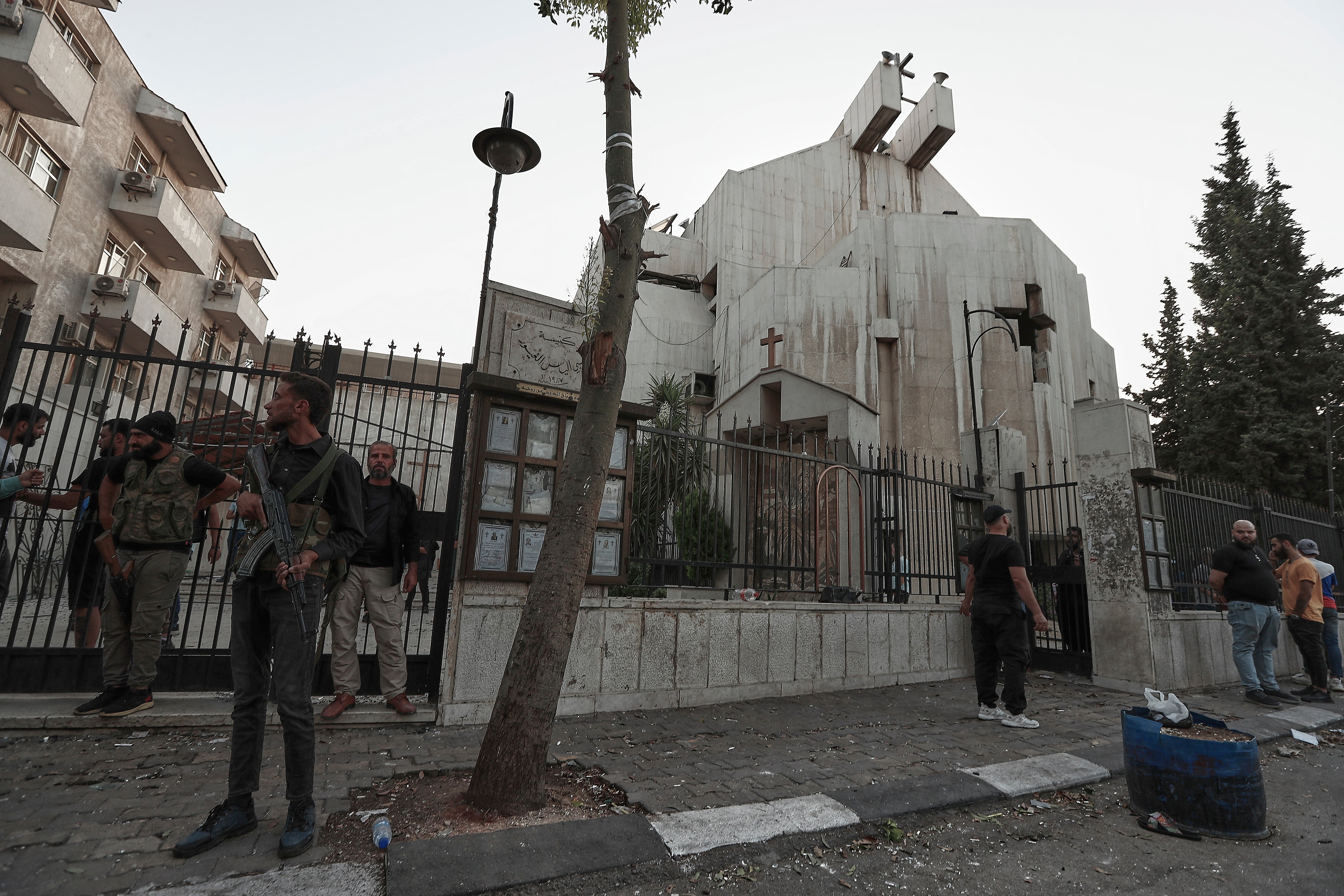 Syrian security forces stand guard outside Mar Elias church in Dweil'a on 22 June 2025