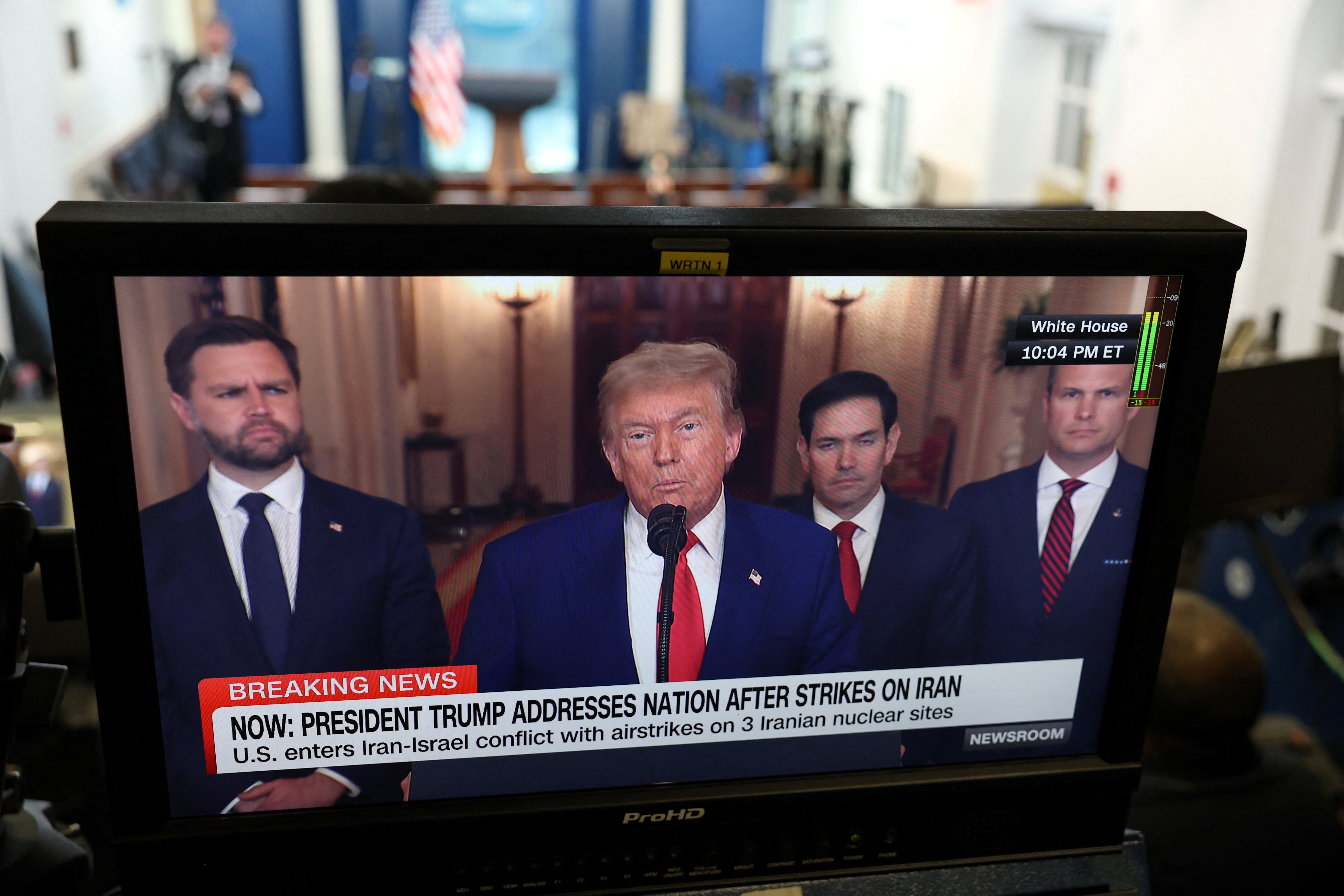 Trump, flanked by Vice President JD Vance, Secretary of State Marco Rubio and Defense Secretary Pete Hegseth, is seen on a TV screen during his address to the nation from the White House