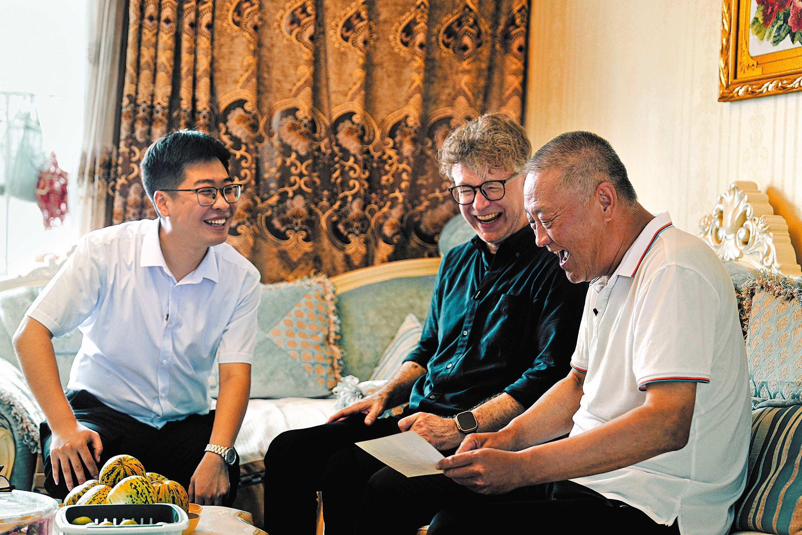 Arthur Jones (middle) and Li Jia (left), an employee of Qinghe Power Plant, at the home of a retired worker of the factory in Tieling, Liaoning province