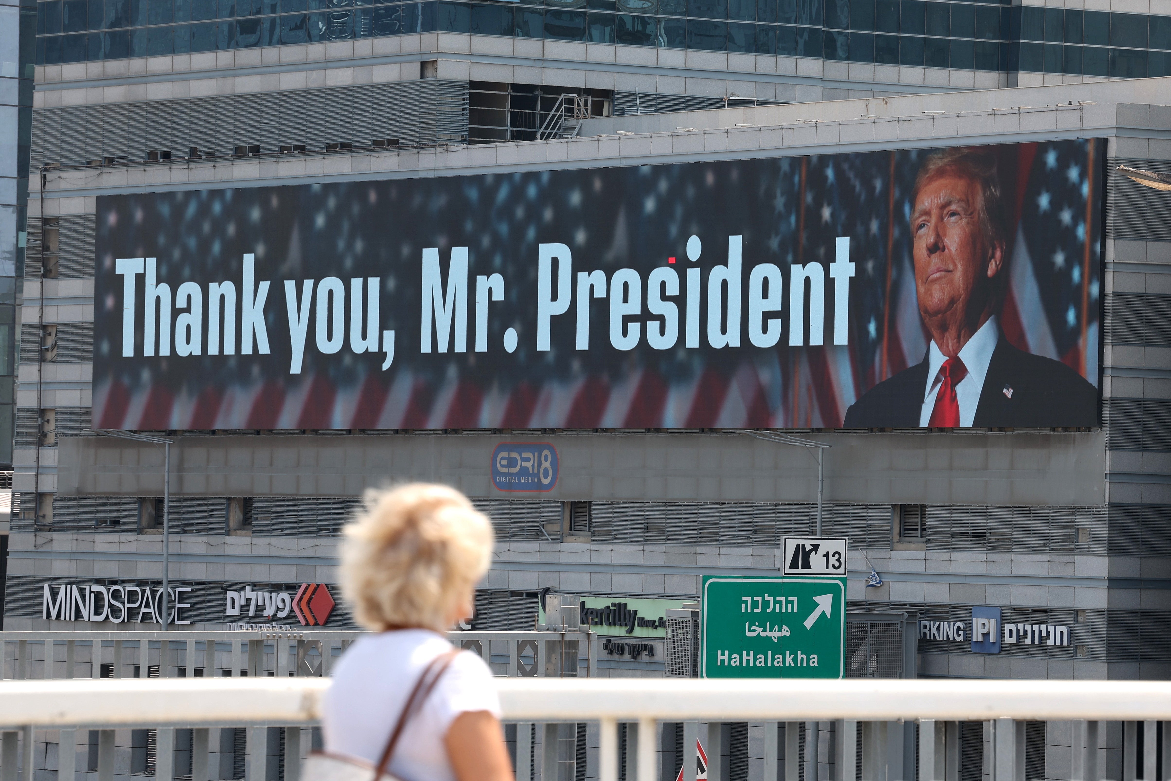 A woman walks past a billboard thanking President Donald Trump in Tel Aviv, Israel after US forces struck three of Iran's key nuclear sites: Natanz, Isfahan and Fordo.