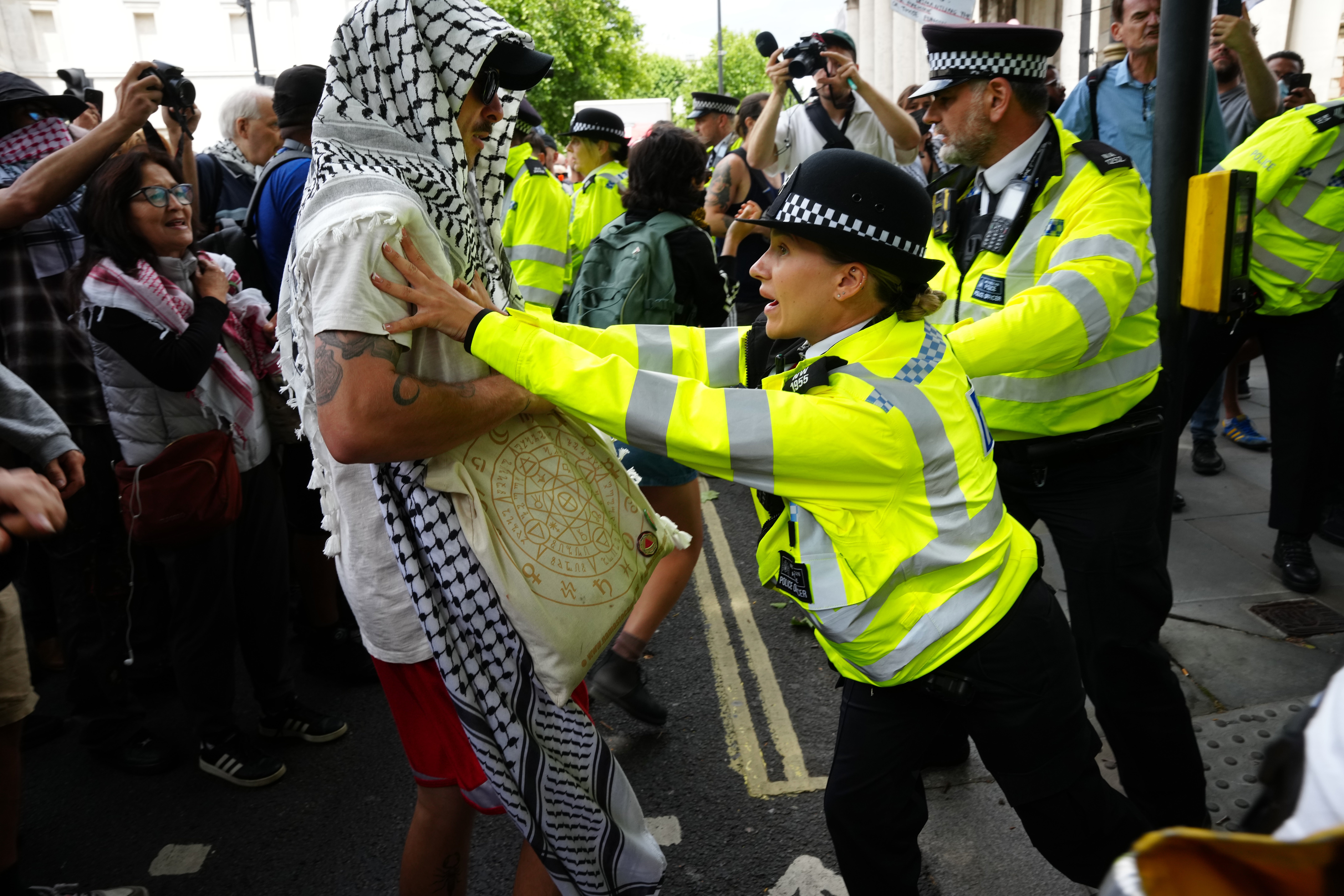 Police officers and protesters during the demonstration at Trafalgar Square