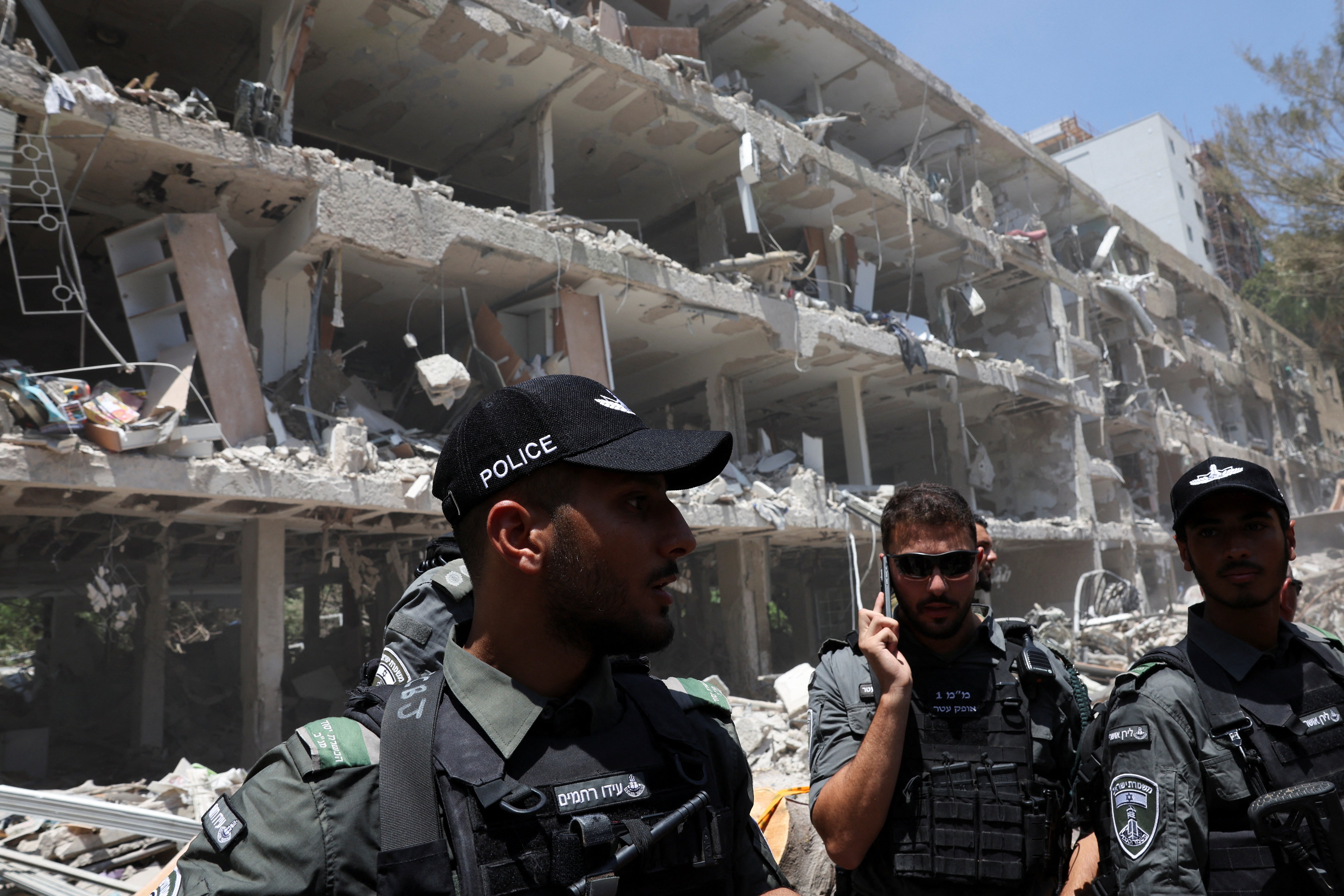 Israeli border police officers work at an impact site following a missile attack from Iran in Tel Aviv on June 22