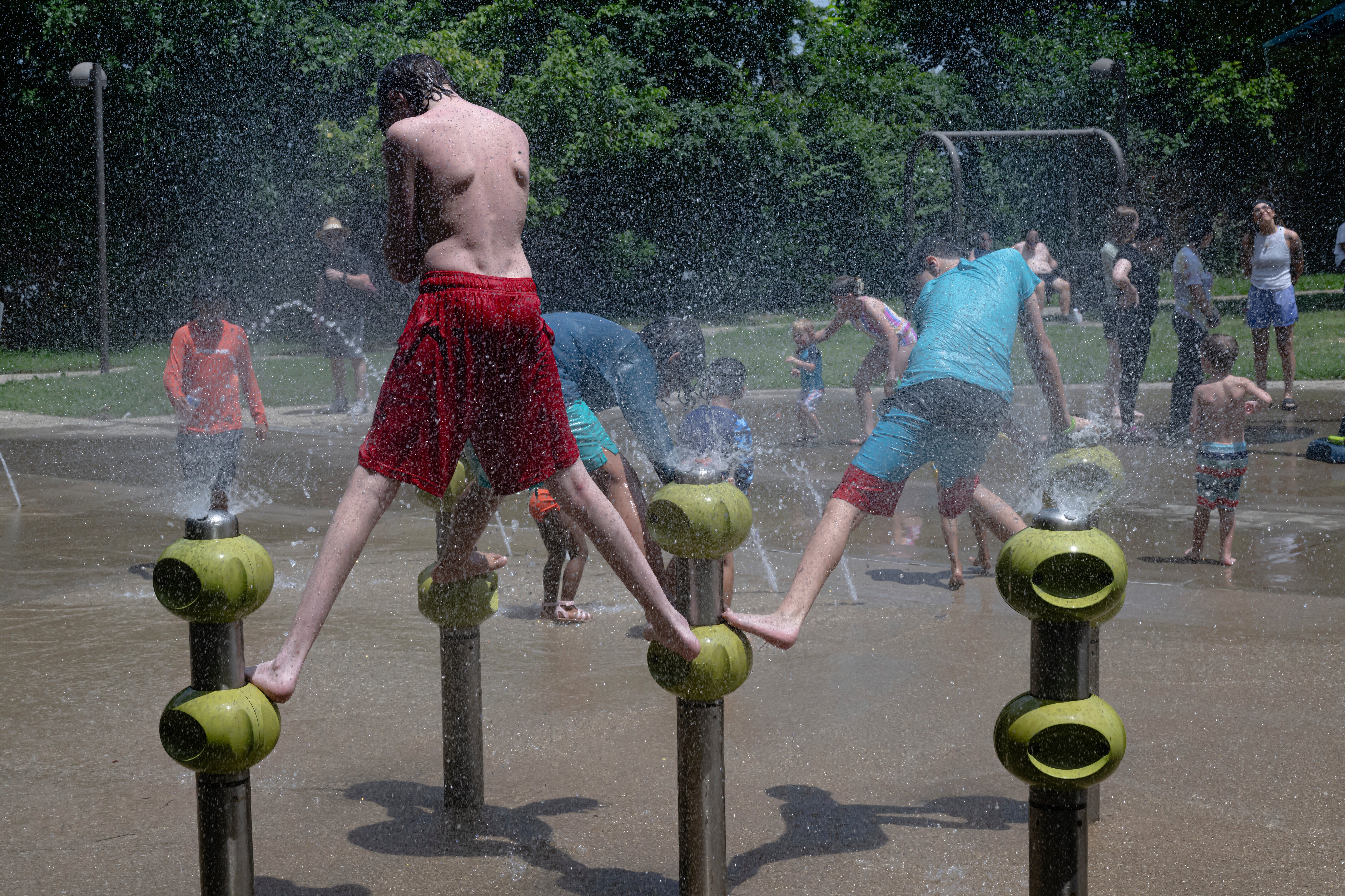 Children in Louisville, Kentucky, play in a park’s water feature. Heat index values there were forecast to exceed 100 degrees