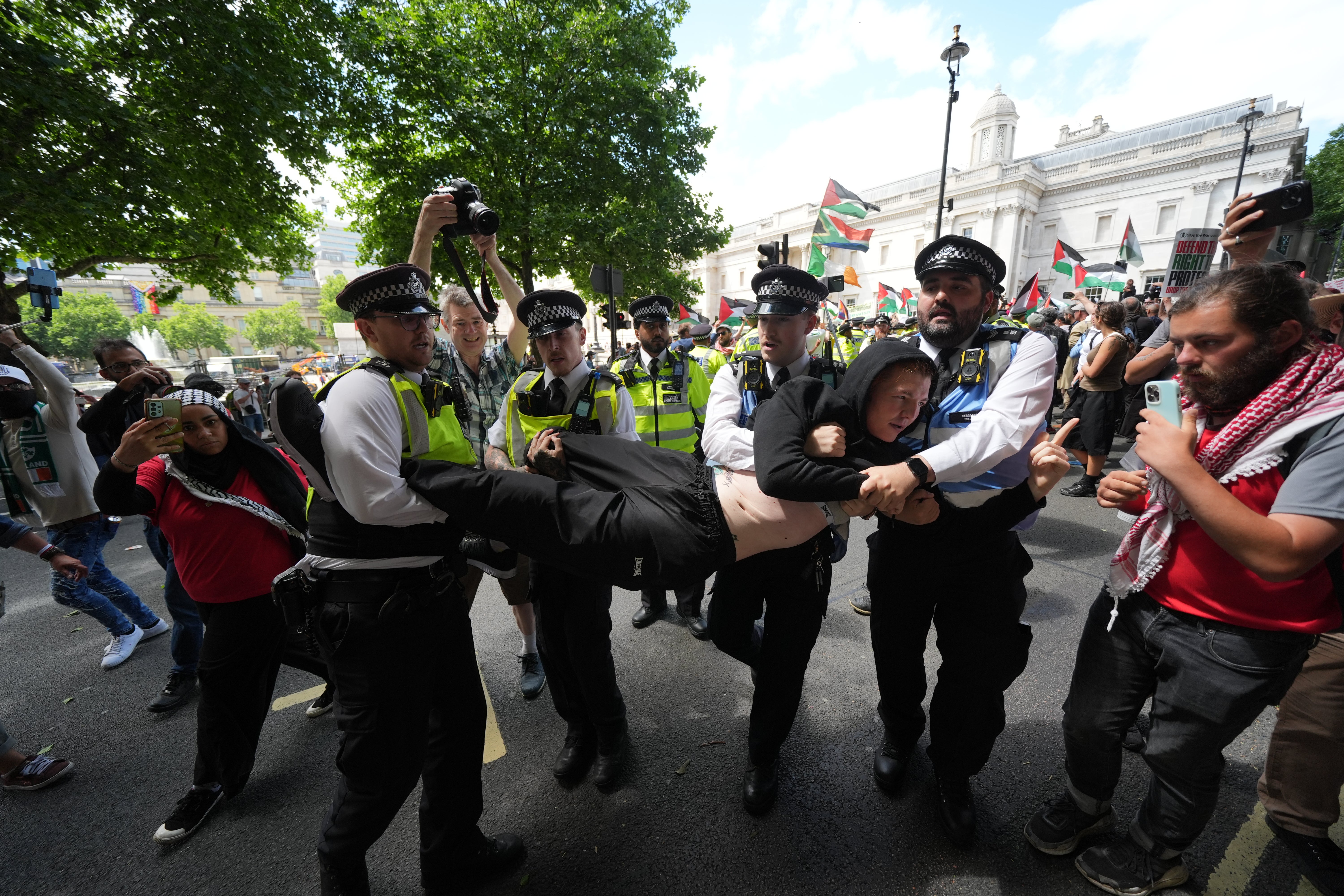 Police remove a person taking part in the protest