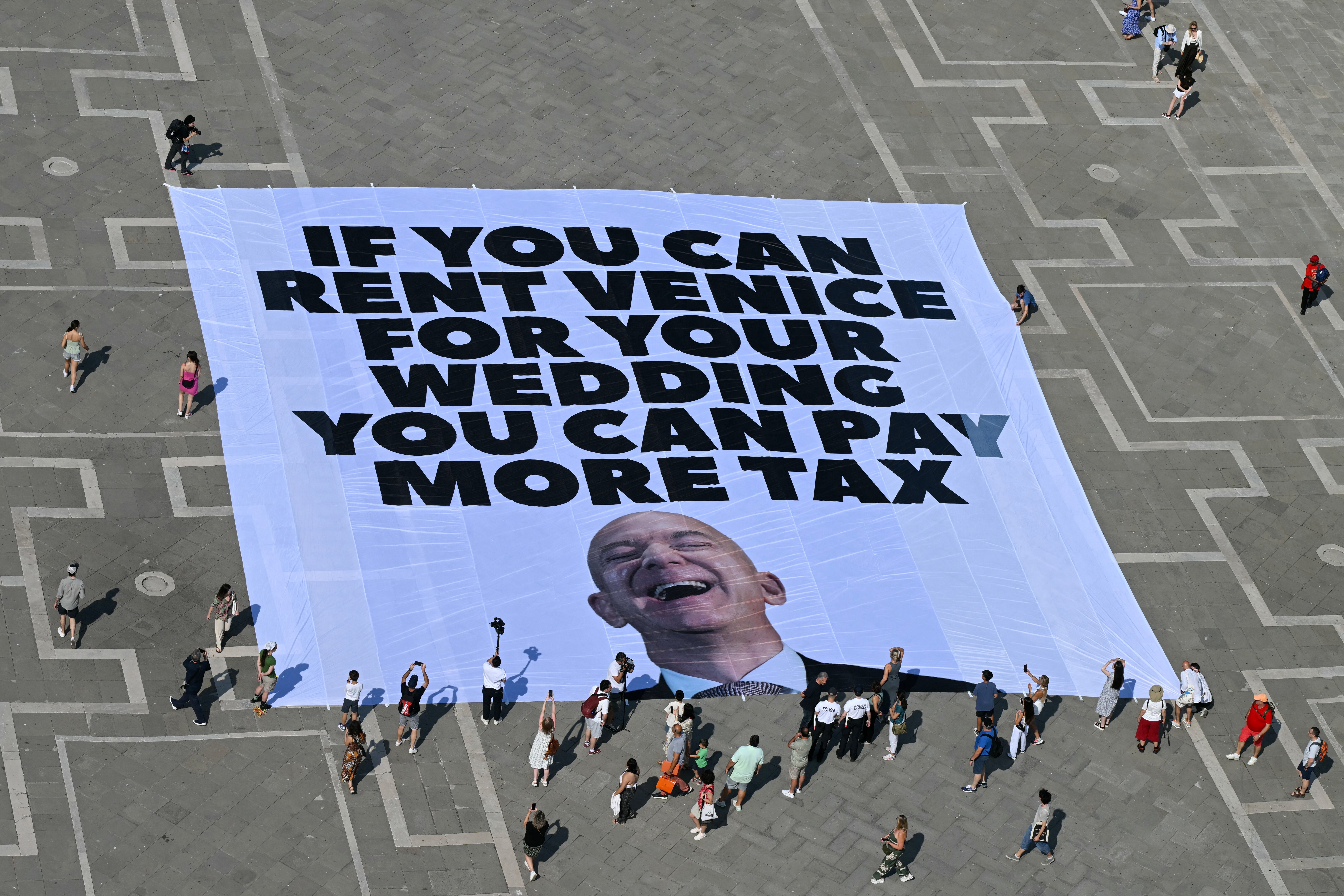 Greenpeace activists deploy a giant banner to protest Jeff Bezos’s wedding in Venice