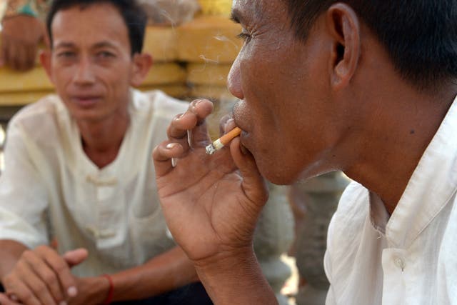 <p>A Cambodian man smokes a cigarette in Phnom Penh</p>