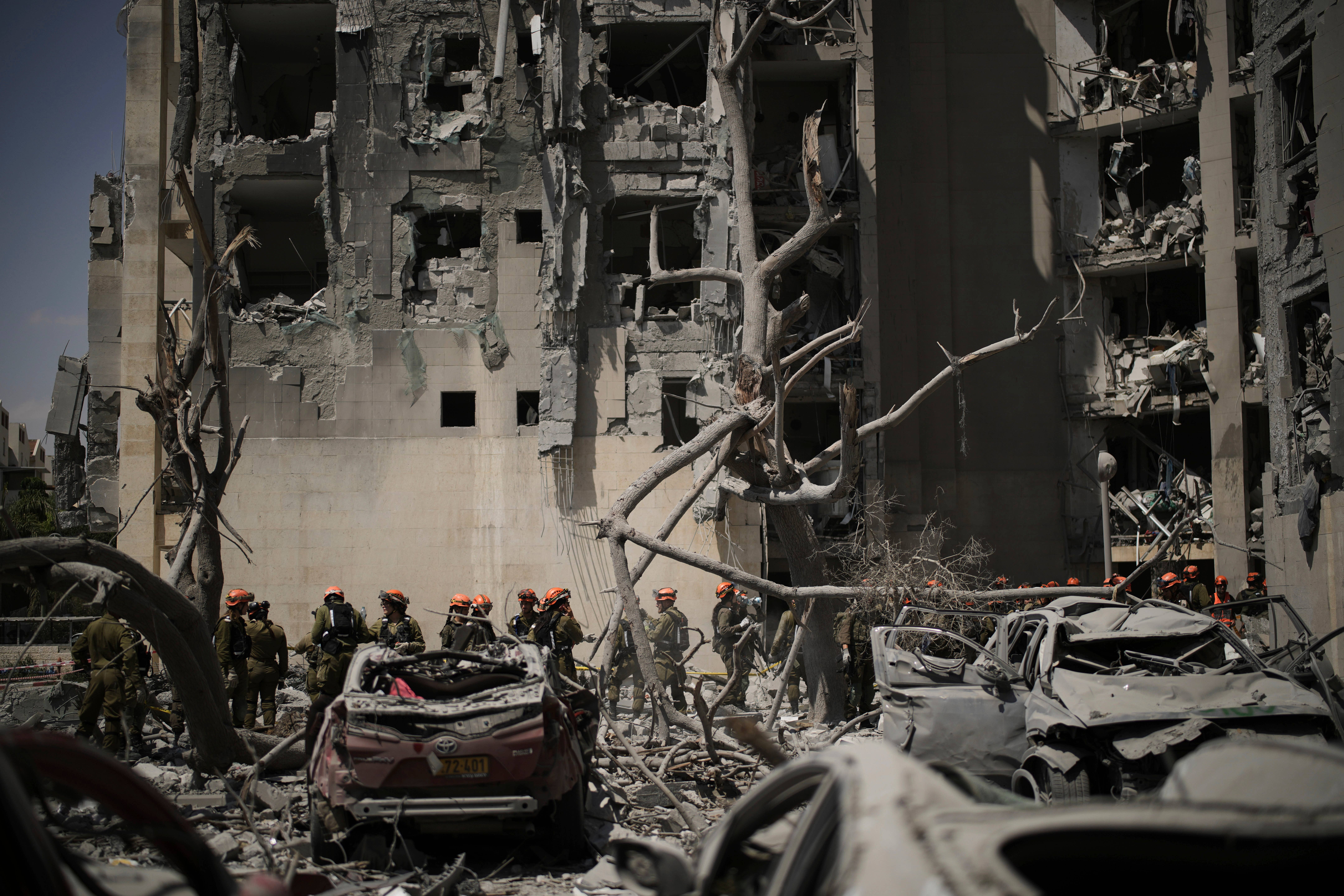 Israeli soldiers from the Home Front Command unit work at the site struck by an Iranian missile strike that killed several people, in Beersheba, Israel, on Tuesday (Leo Correa/AP)