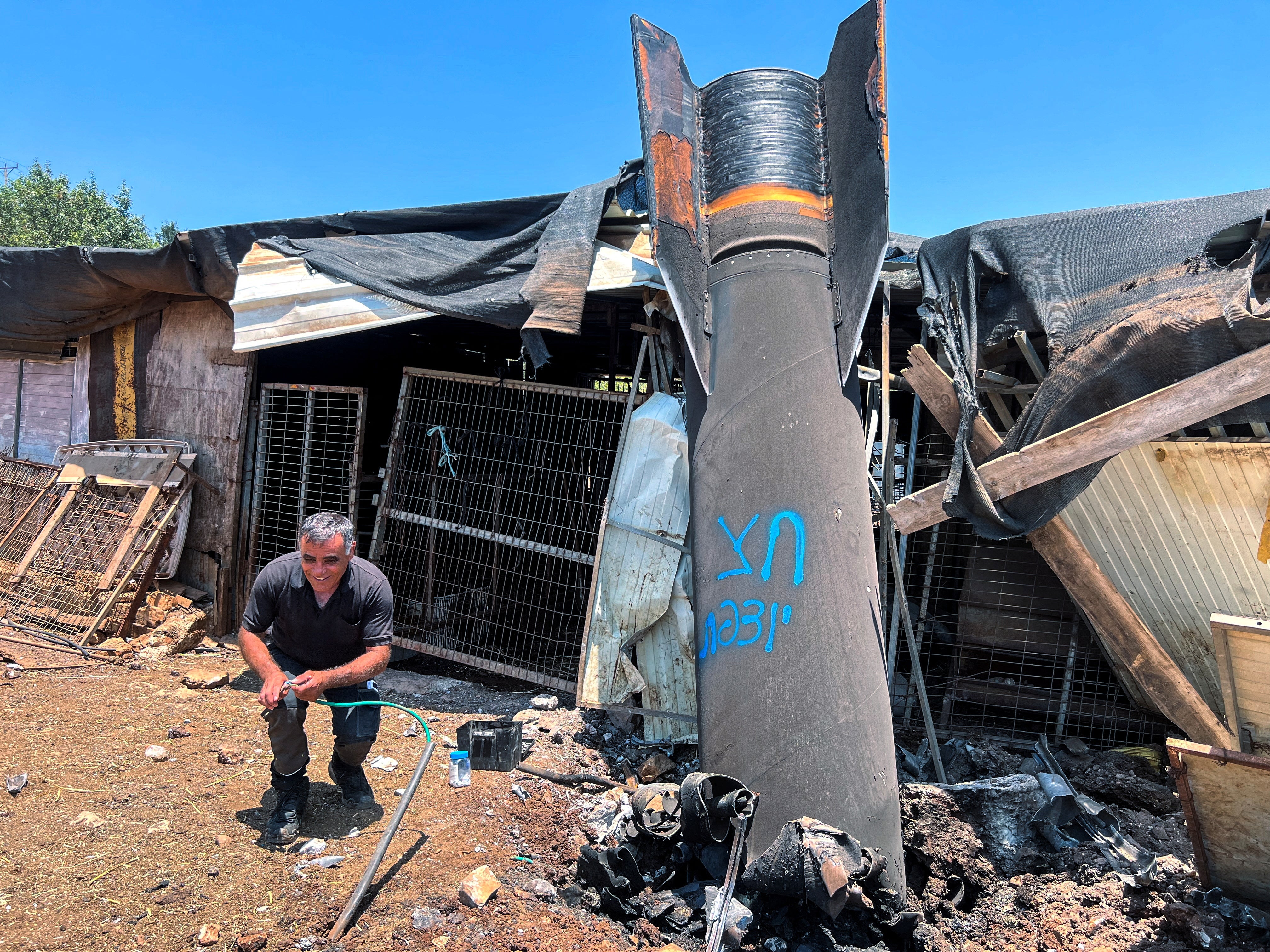 A man poses next to apparent remains of a ballistic missile following Tuesday’s missile attack by Iran on Israel