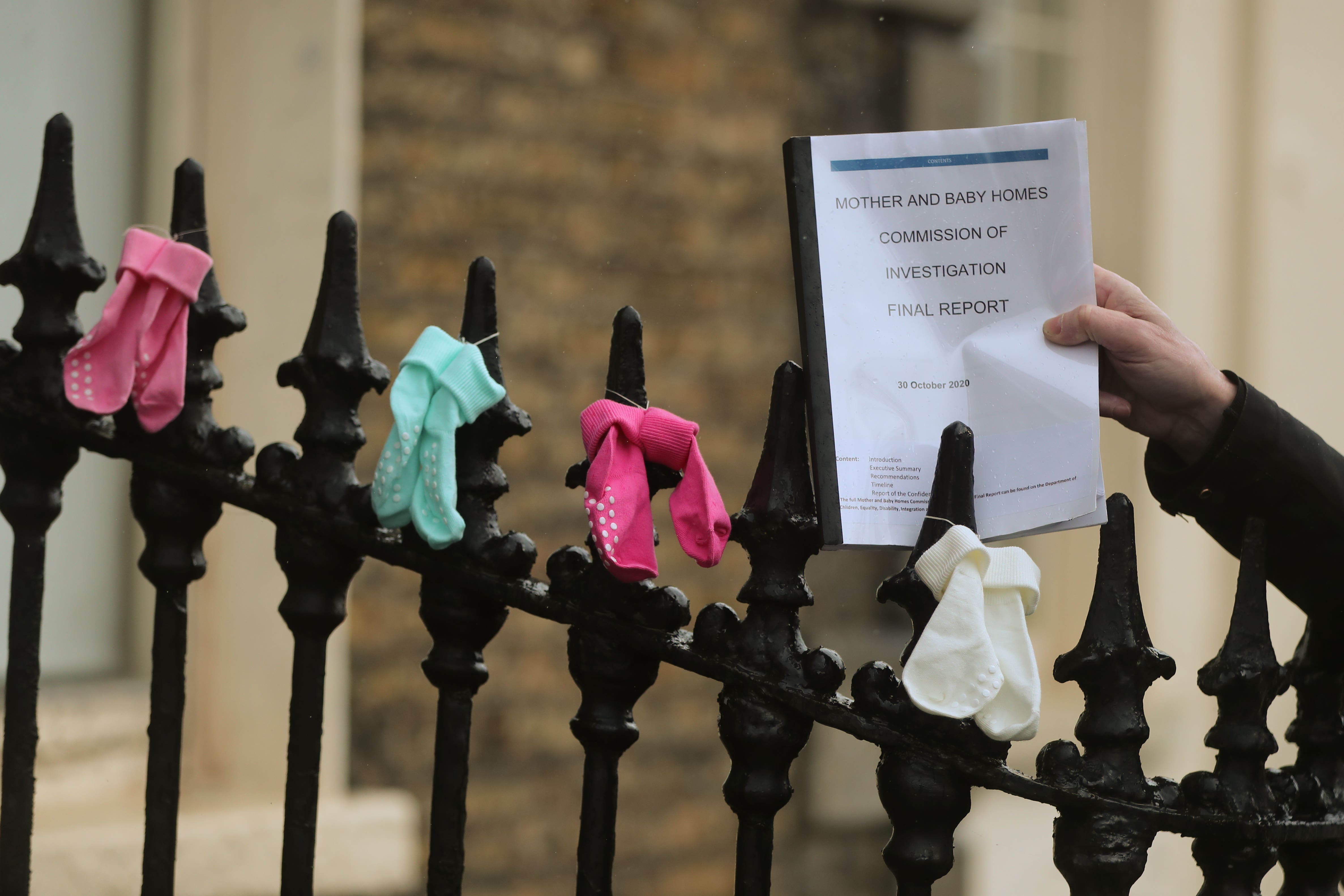 Mother and Baby home survivor Mel Cannon holds a copy the Irish Mother and Baby Home report while taking part in a protest outside the offices of the Irish Mother and Baby Home Commission in Dublin (Niall Carson/PA)