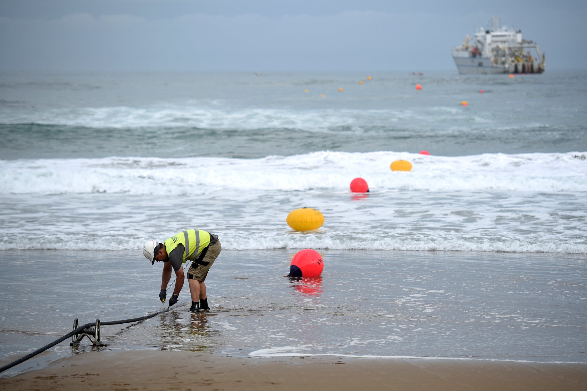 An operator works on an undersea fibre optic cable at Arrietara Beach in Spain