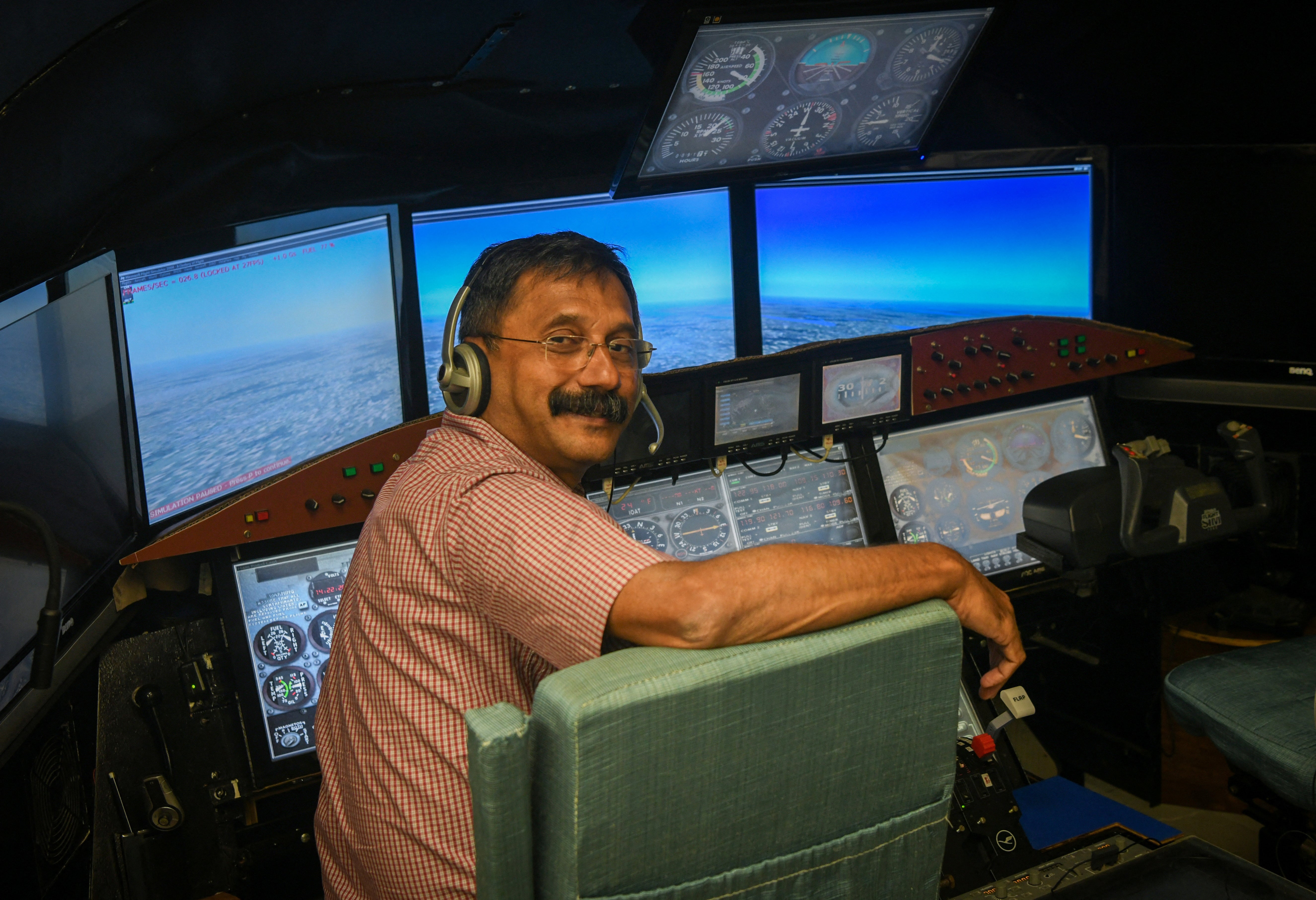 Retired Indian Air Force (IAF) wing commander K. Dinesh poses for pictures in a cockpit simulator room, after an interview with Reuters, at Cockpit Vista in Bengaluru, India June 23, 2025