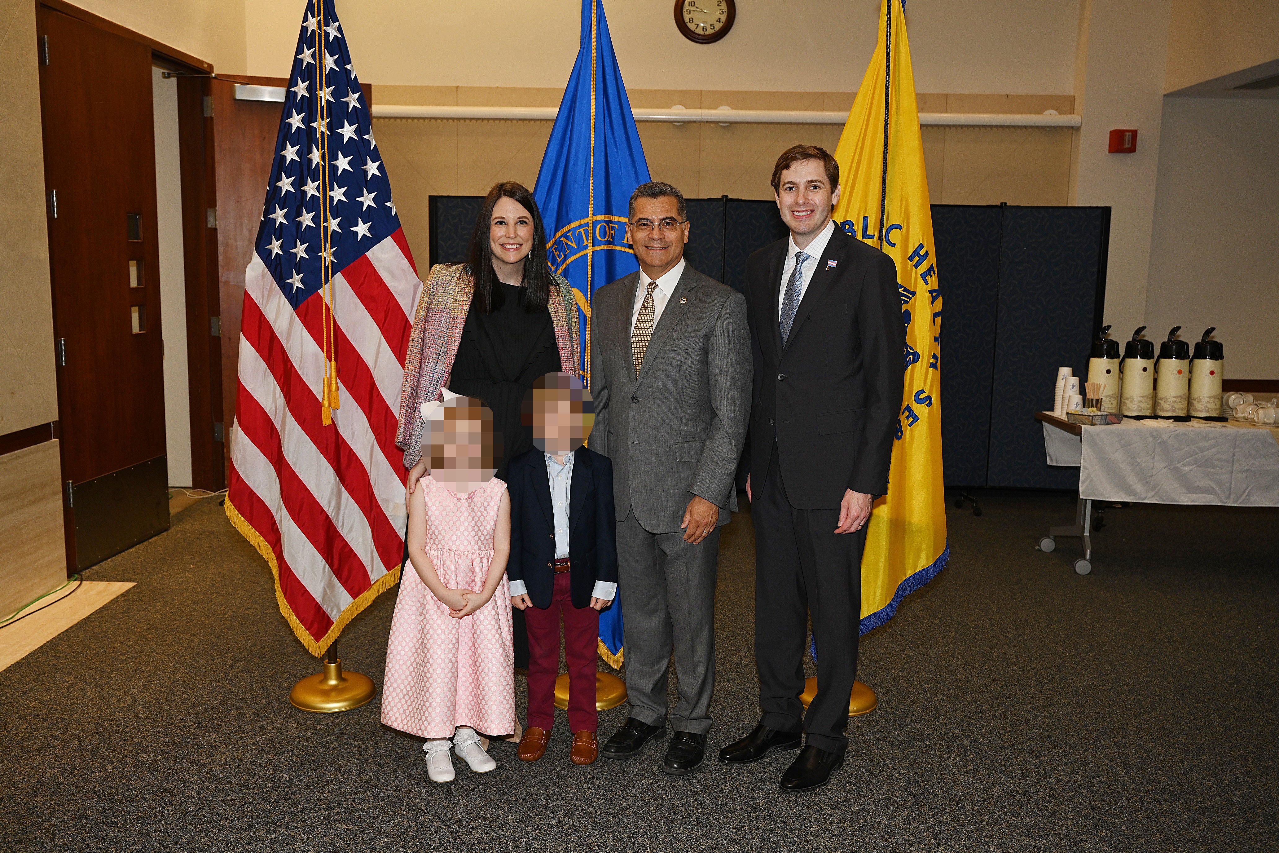 Stacy Davis , John Davis, and their children pose with former Biden administration health secretary Xavier Becerra, center