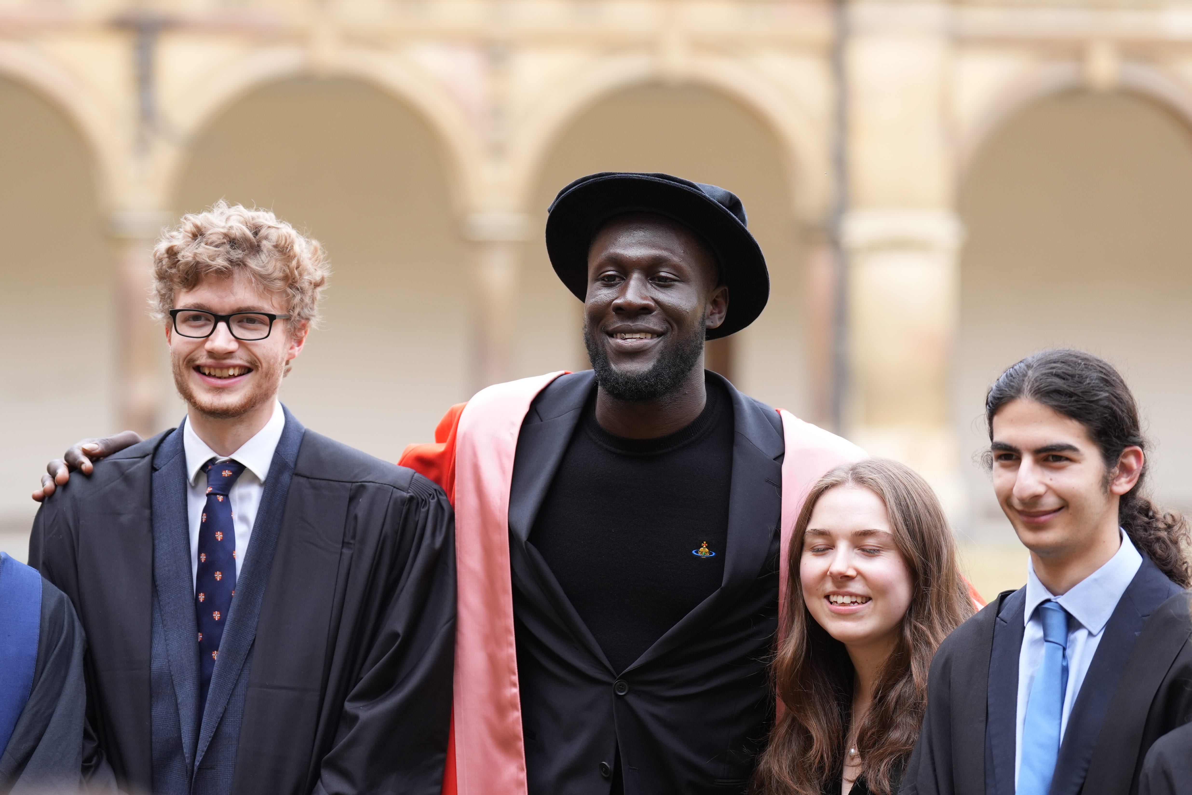 Stormzy has a picture with students after receiving his honorary degree from Cambridge University (PA)