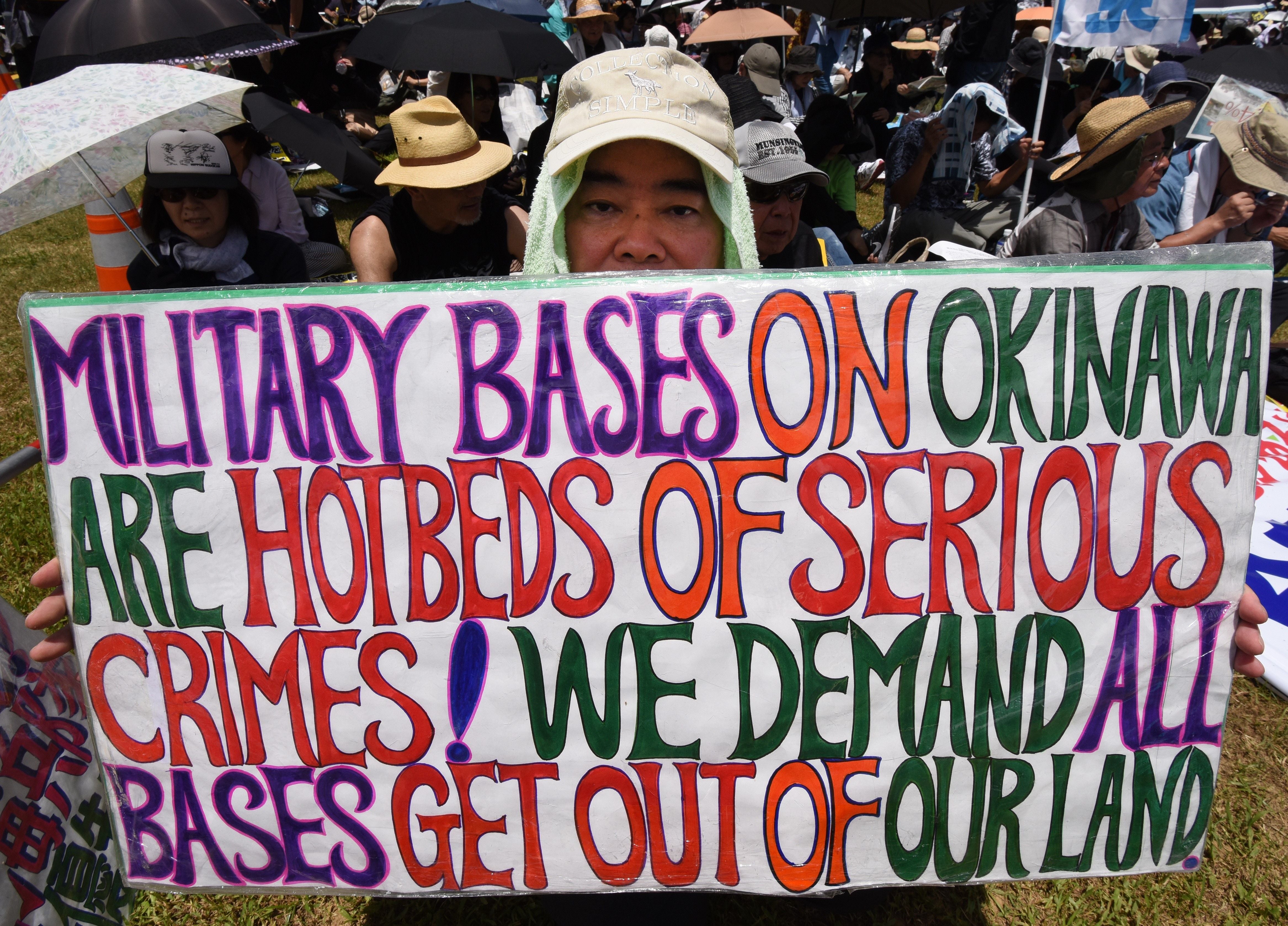 A demonstrator holds a placard during a rally against American military presence in Naha