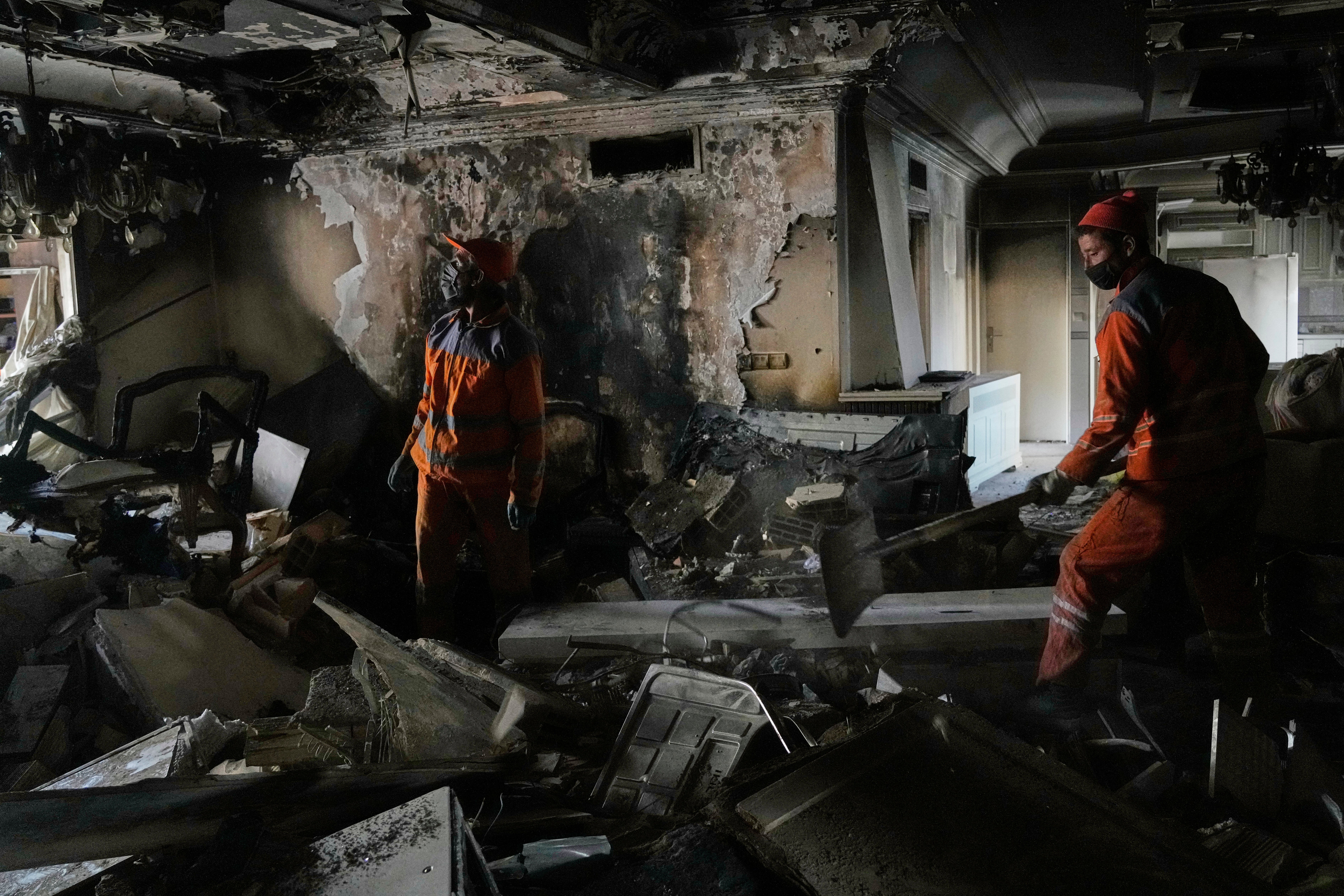 Workers clear rubble after a damaged building after an Israeli strike
