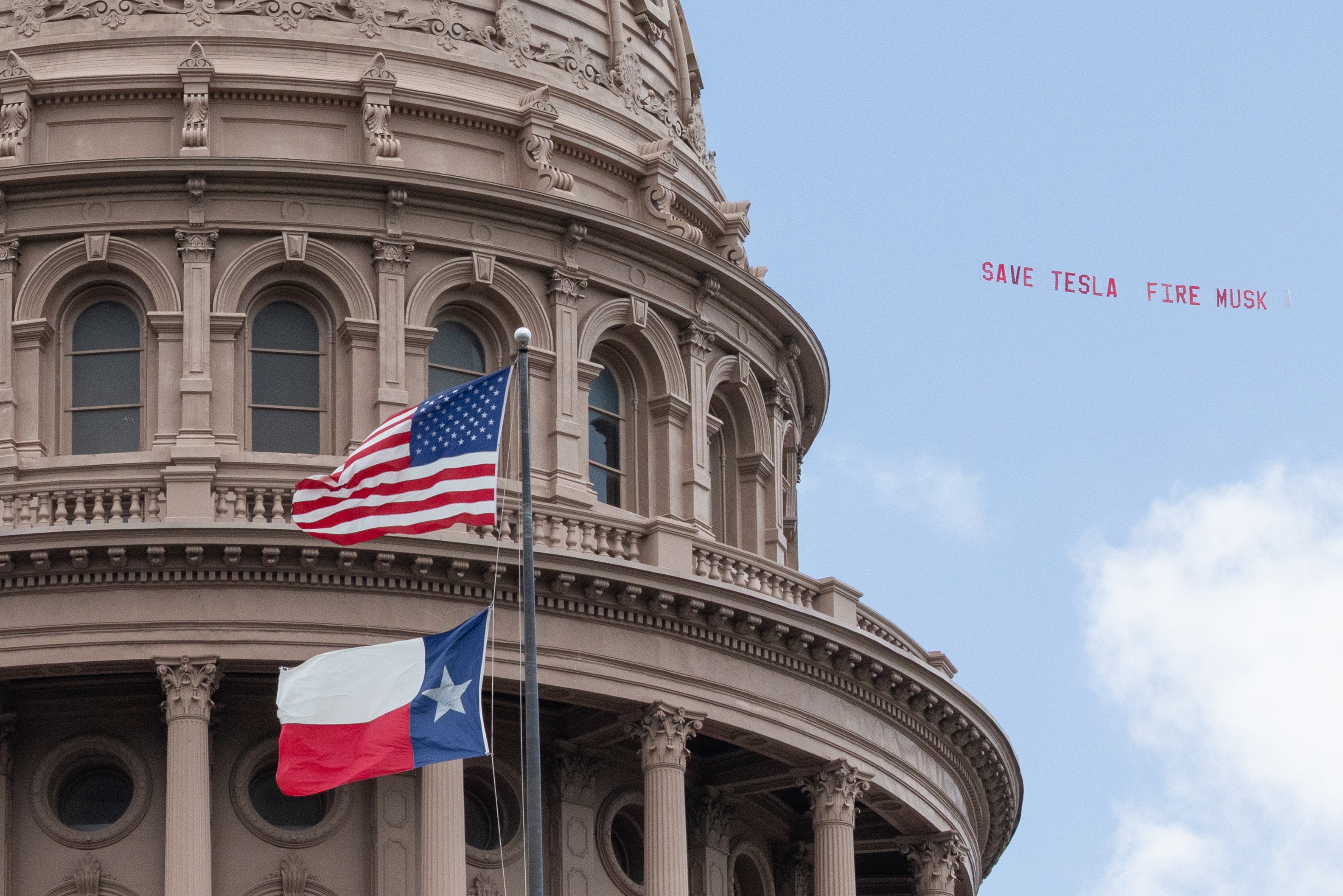 A banner reading ‘Save Tesla, Fire Musk’ is flown over Austin during the launch of the robotaxis