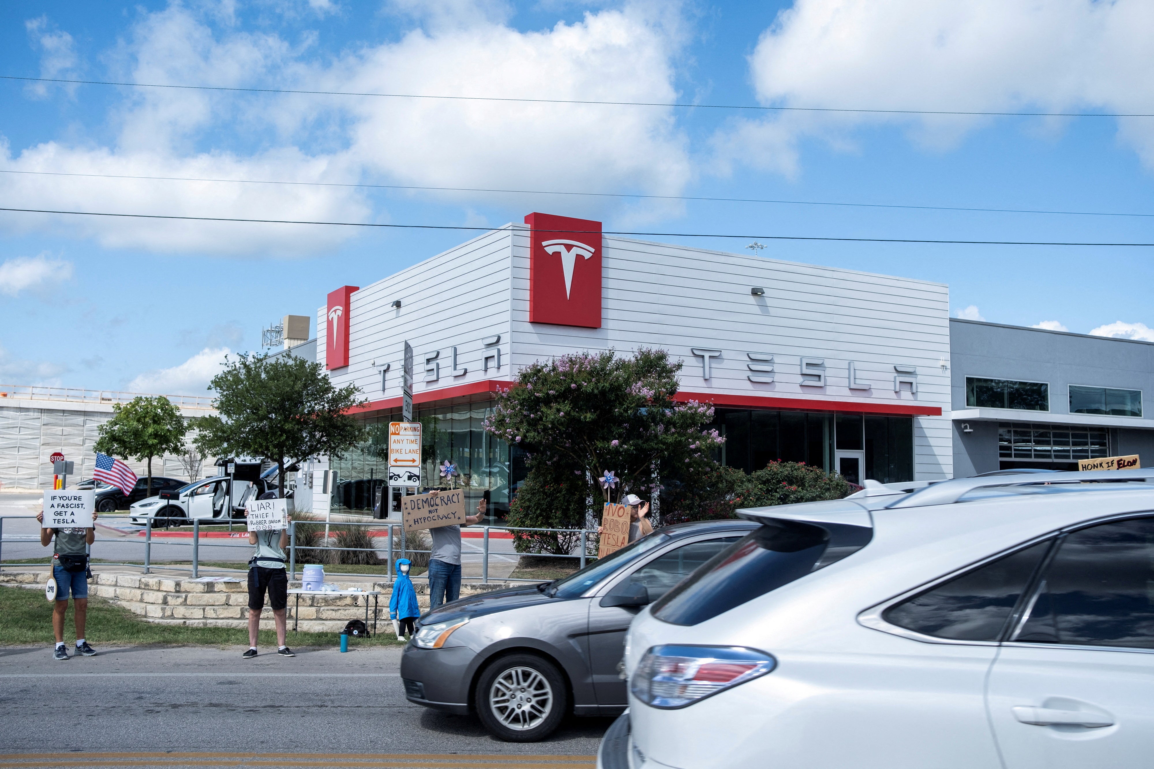 Demonstrators protest against Tesla and Musk outside a Tesla service centre in Austin