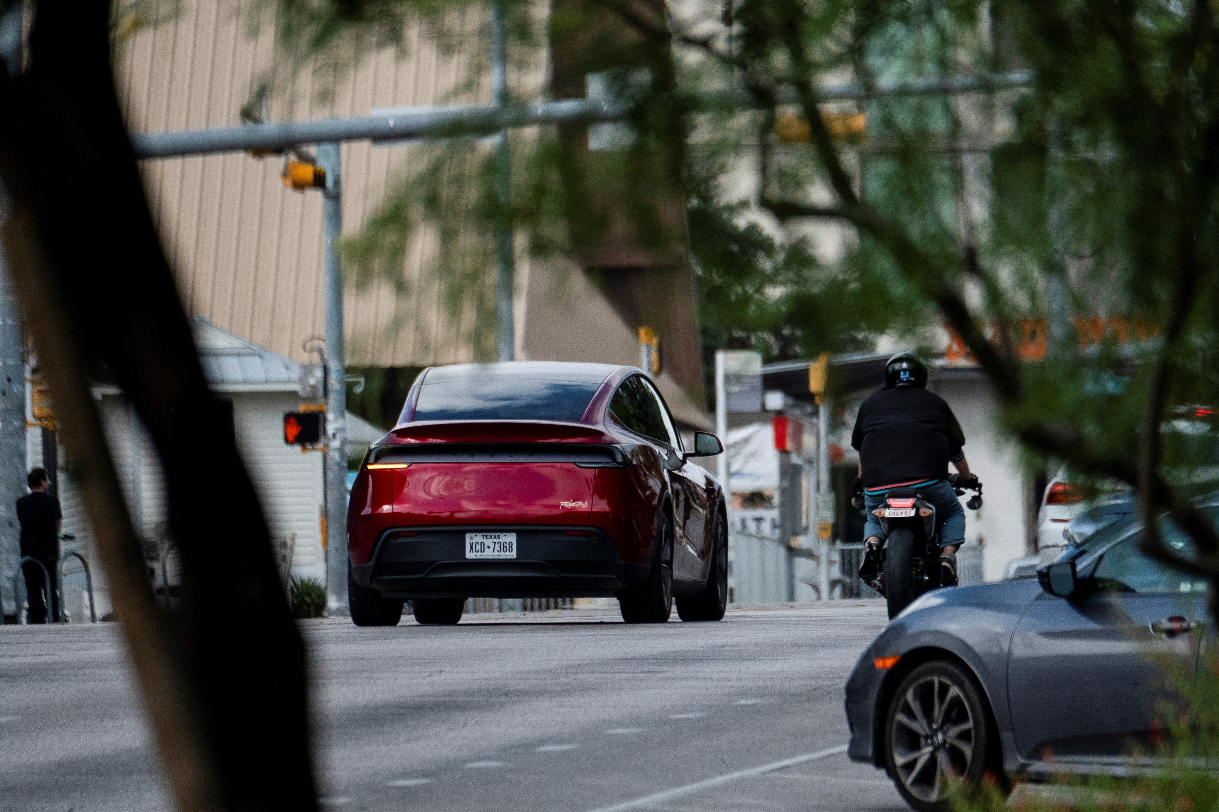 A Tesla robotaxi with no backseat passengers drives on the street along South Congress Avenue in Austin, Texas