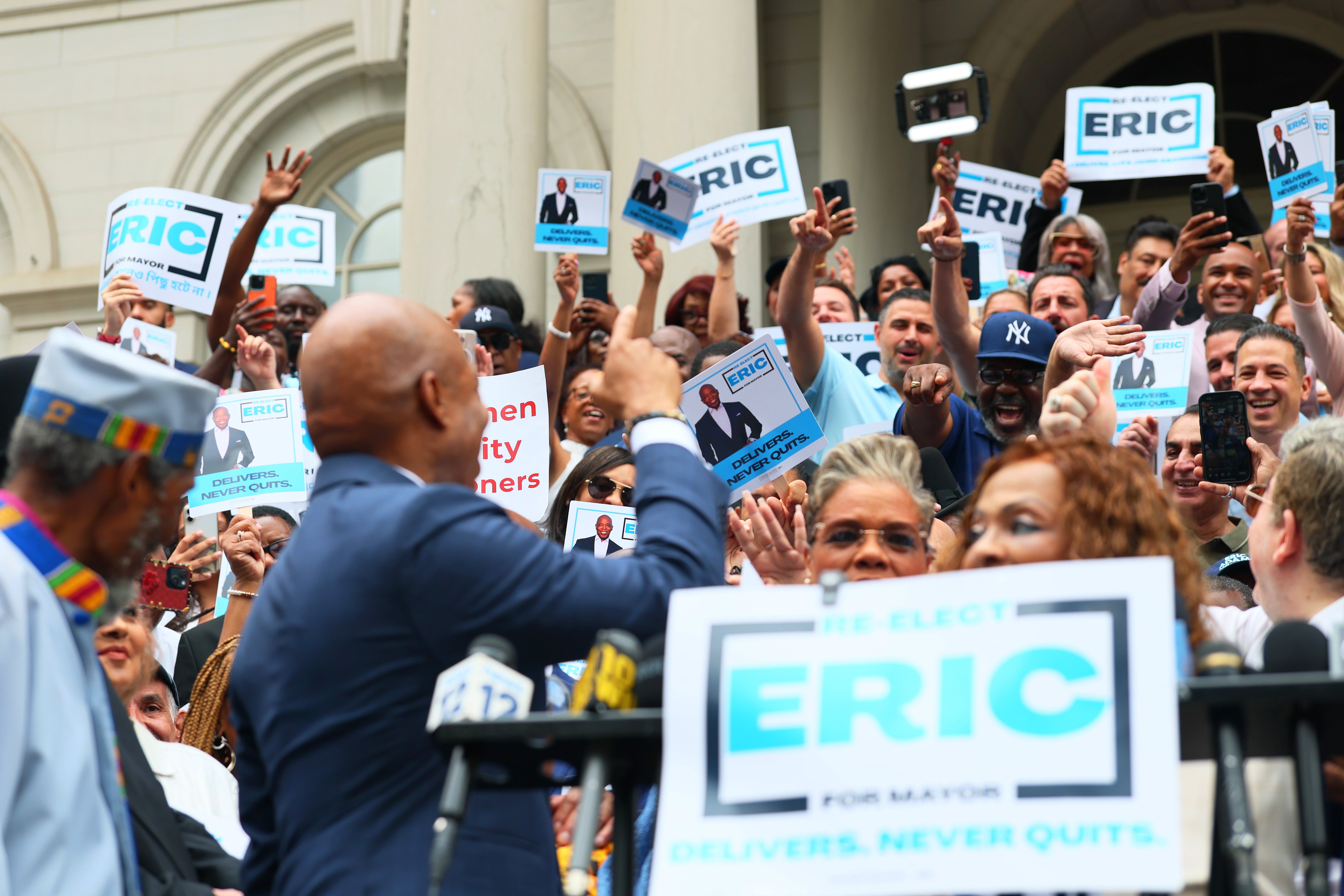 Adams waved his hand at the crowd in an attempt to quiet them down.