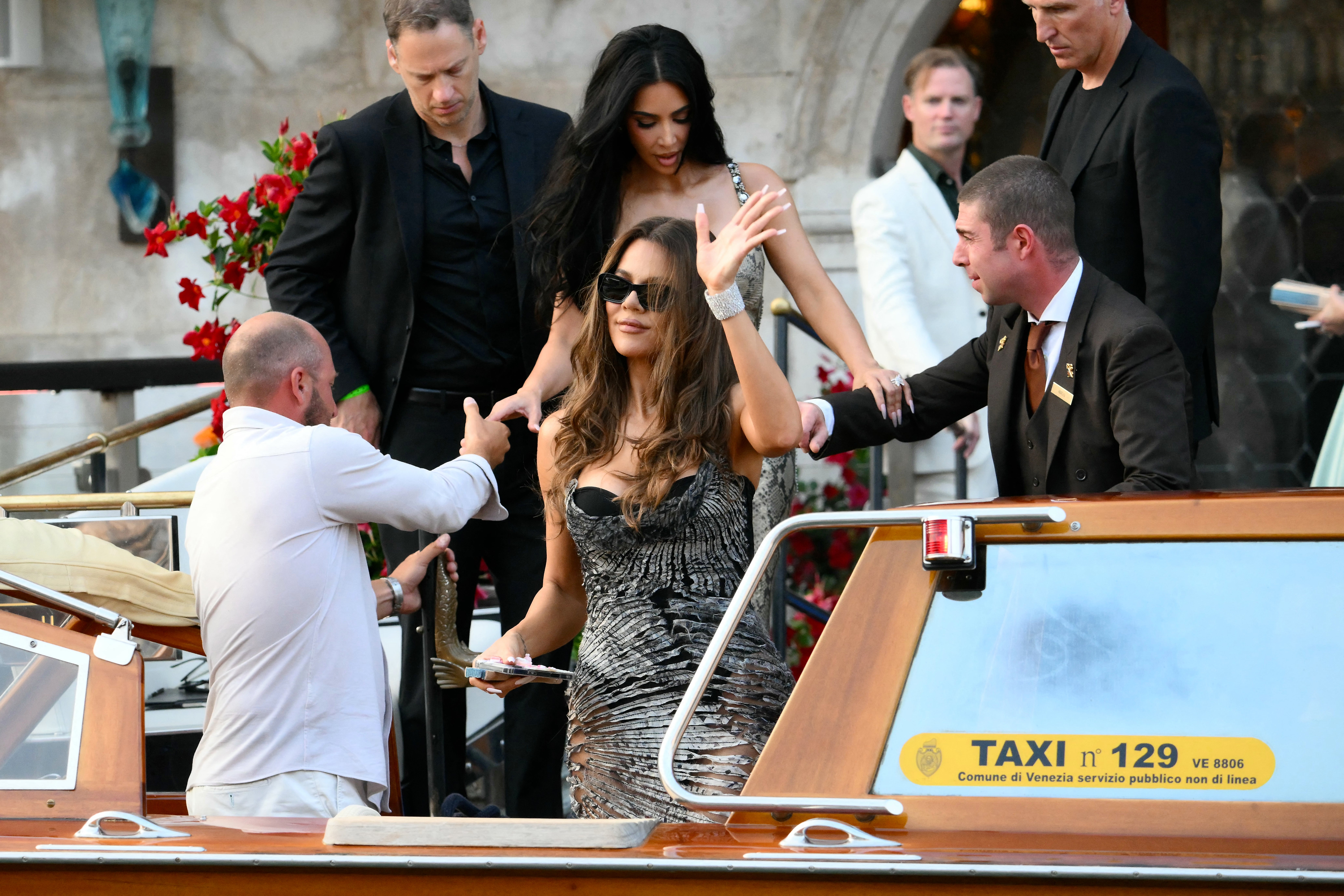 Khloe Kardashian headed to Bezos’s welcome party in a black corset, worn underneath a silver printed dress. The design of the gown was a bit messy, appearing slightly cut open in various spots