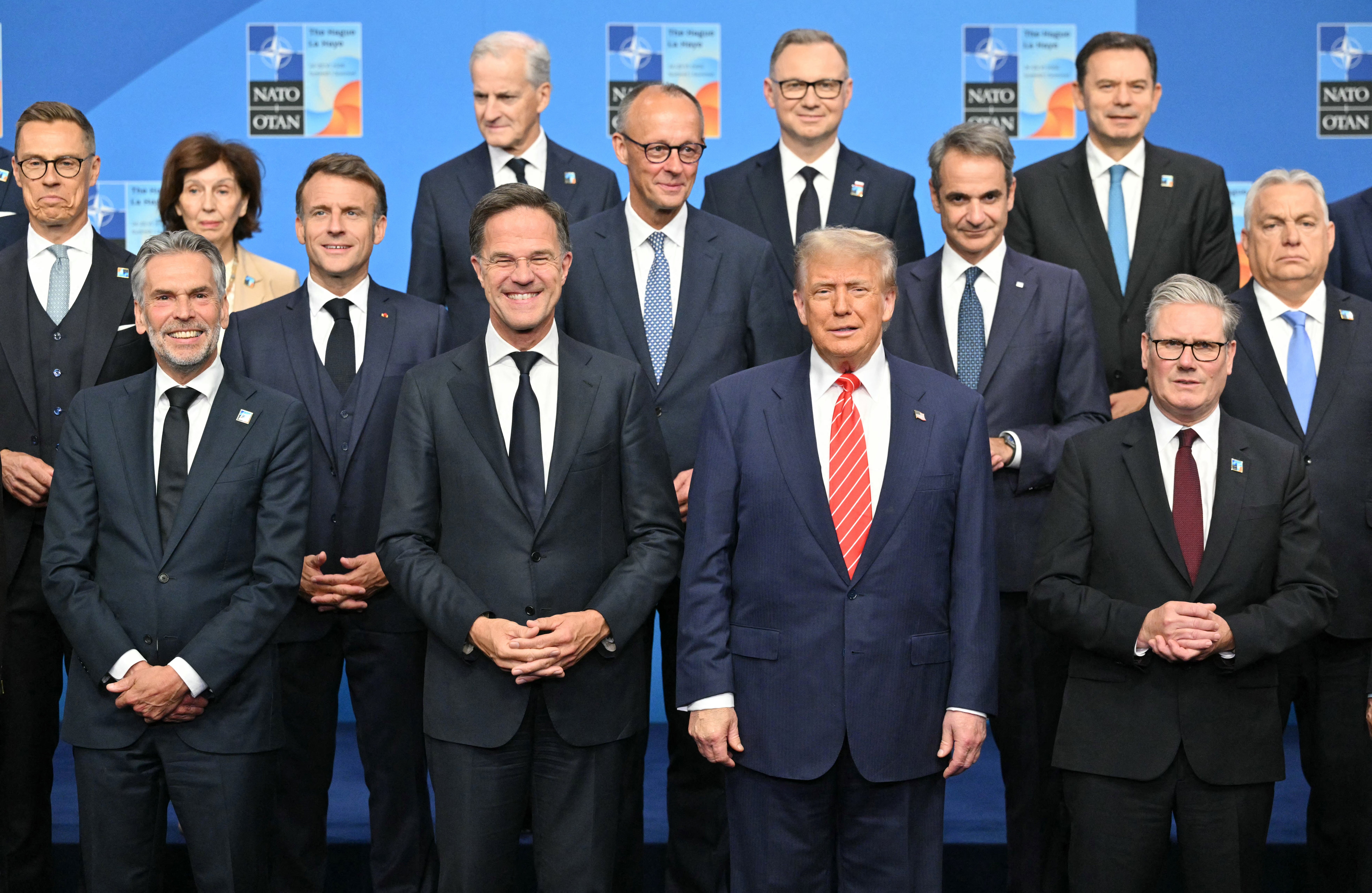 (Front from L) Finland's President Alexander Stubb, Netherlands' Prime Minister Dick Schoof, France's President Emmanuel Macron, NATO Secretary General Mark Rutte, US President Donald Trump, Greece's Prime Minister Kyriakos Mitsotakis, Britain's Prime Minister Keir Starmer, Hungary's Prime Minister Viktor Orban stand with NATO country leaders for a family photo during the North Atlantic Treaty Organization (NATO) Heads of State and Government summit in The Hague, on June 25, 2025. NATO leaders hold a two-day summit on June 24 and 25 in The Hague. (Photo by NICOLAS TUCAT / AFP) (Photo by NICOLAS TUCAT/AFP via Getty Images)