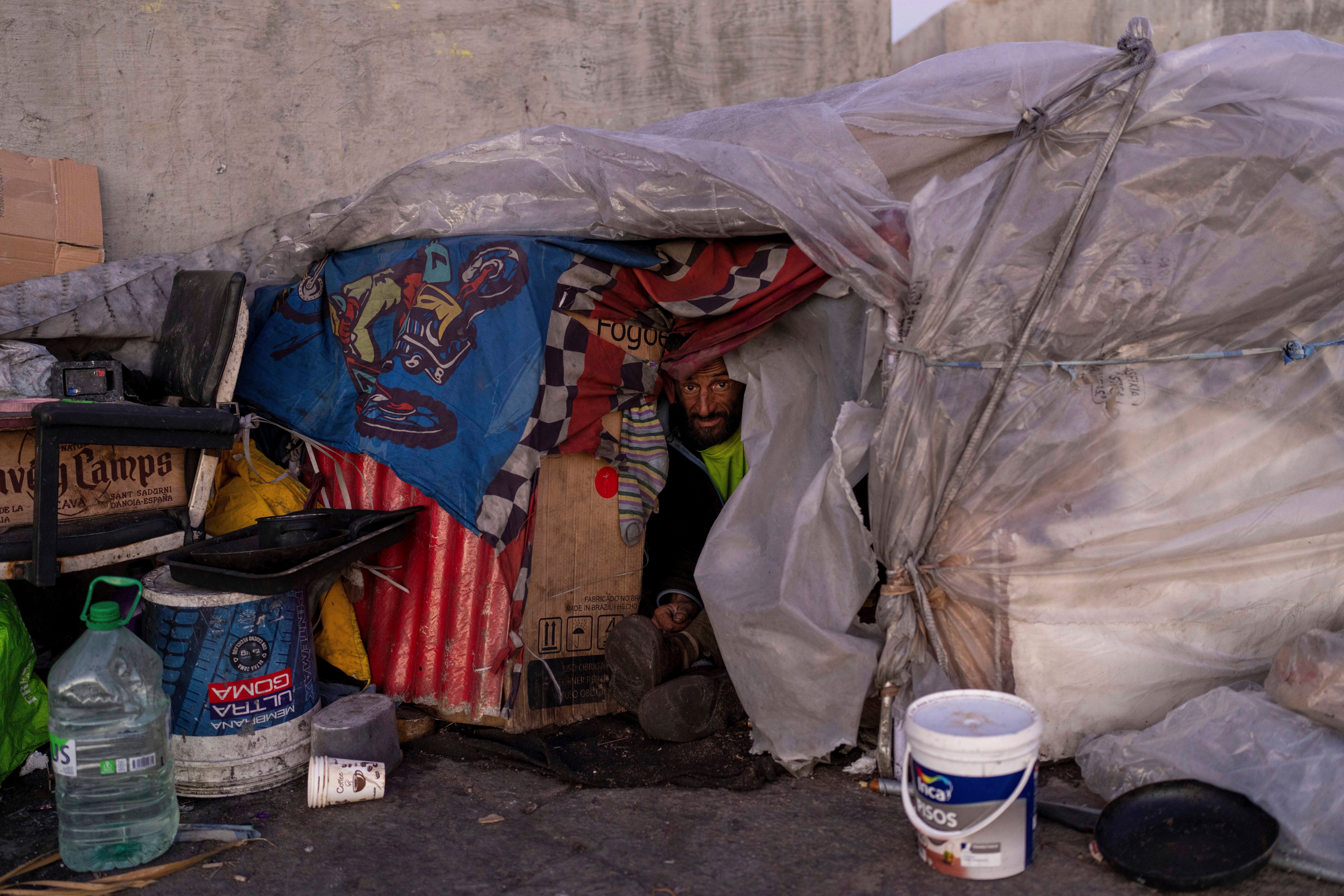 Luis Santacruz looks out from his makeshift home during cold weather in downtown Montevideo