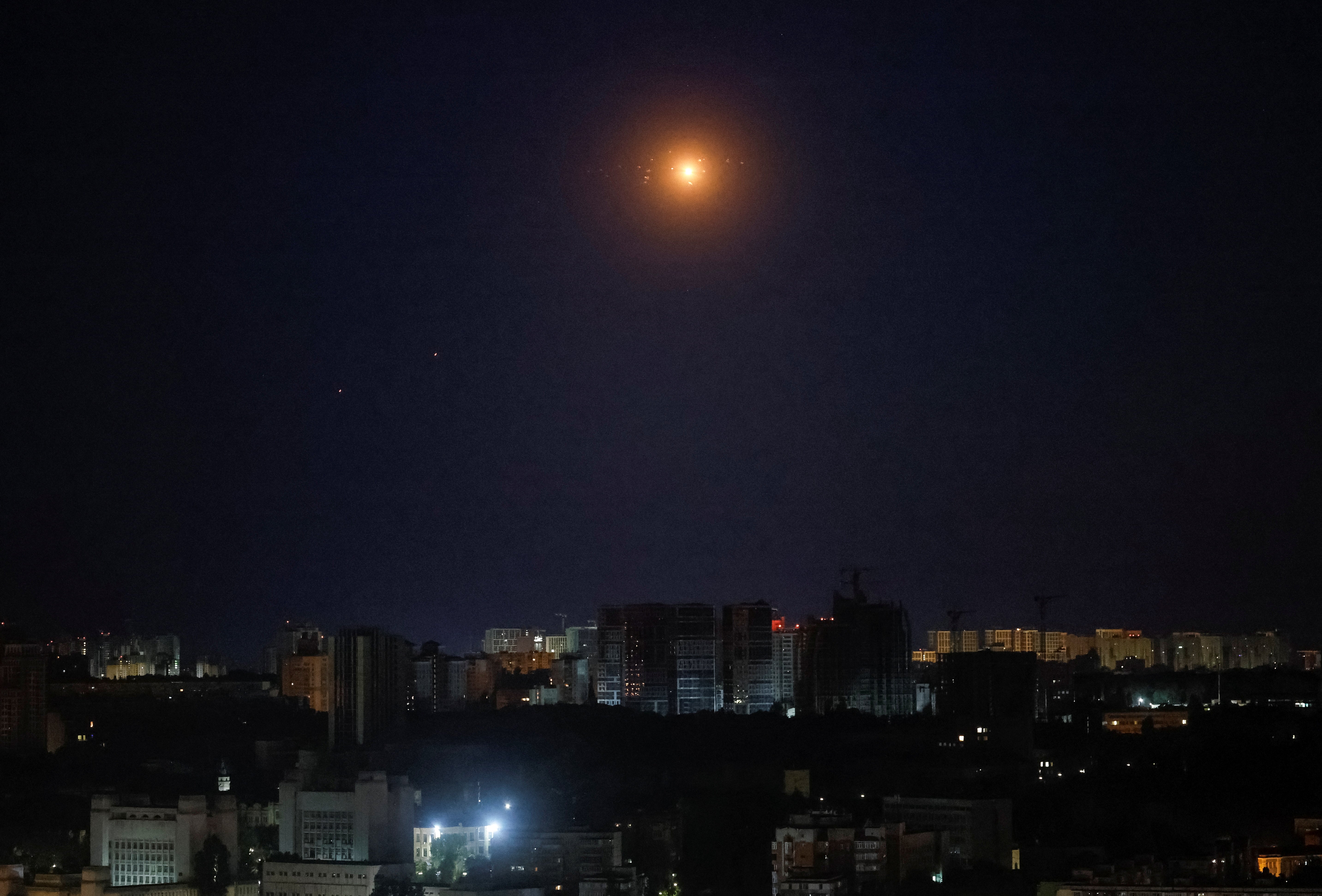 Explosions are seen in the night sky as Ukrainian servicemen fire towards drones during a Russian drone strike, amid Russia's attack on Ukraine, in Kyiv, Ukraine June 27, 2025