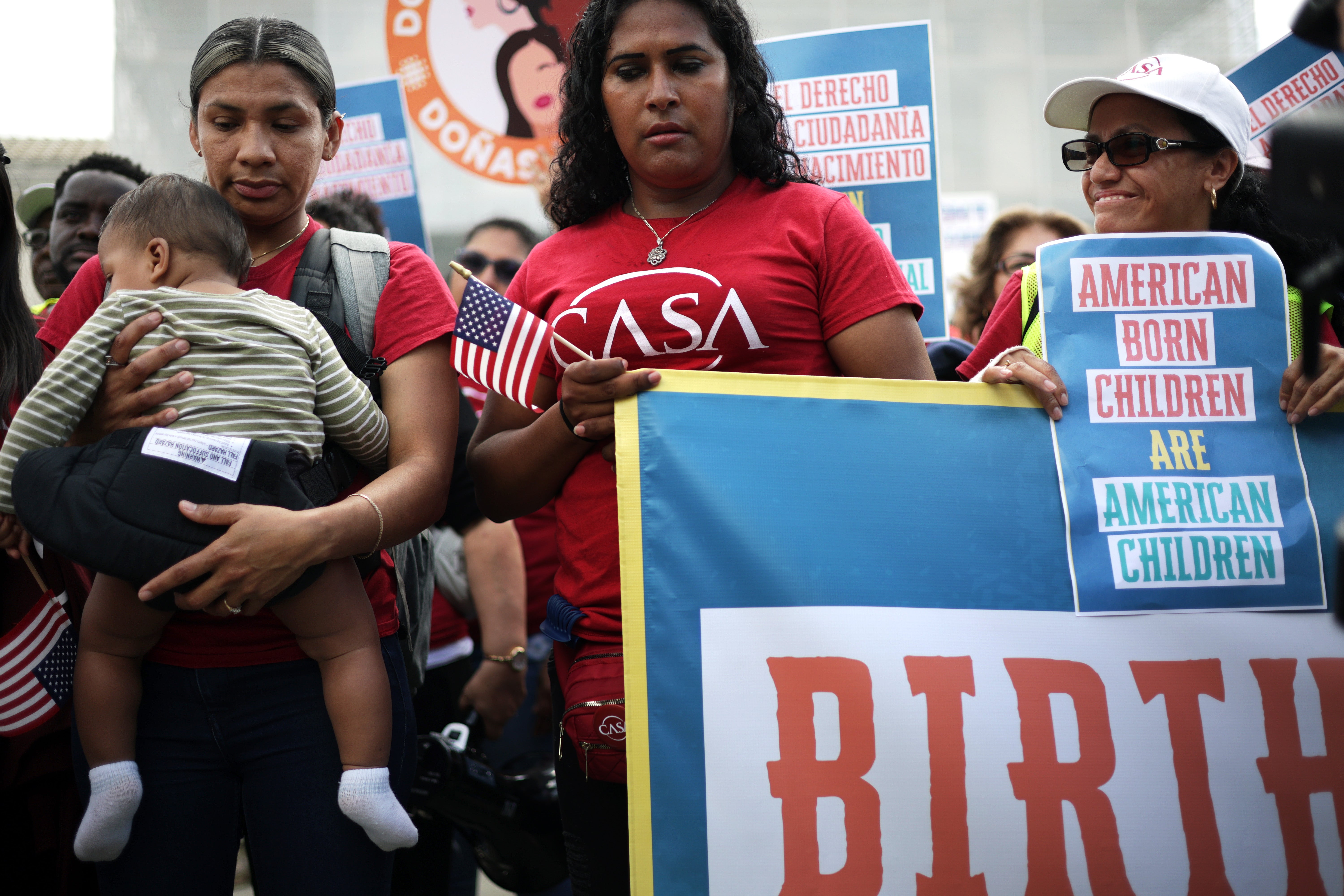 Olga Urbina, left, and her 9-month-old son Ares Webster join demonstrations outside the Supreme Court on May 14 as justices grilled the Trump administration over challenges to birthright citizenship