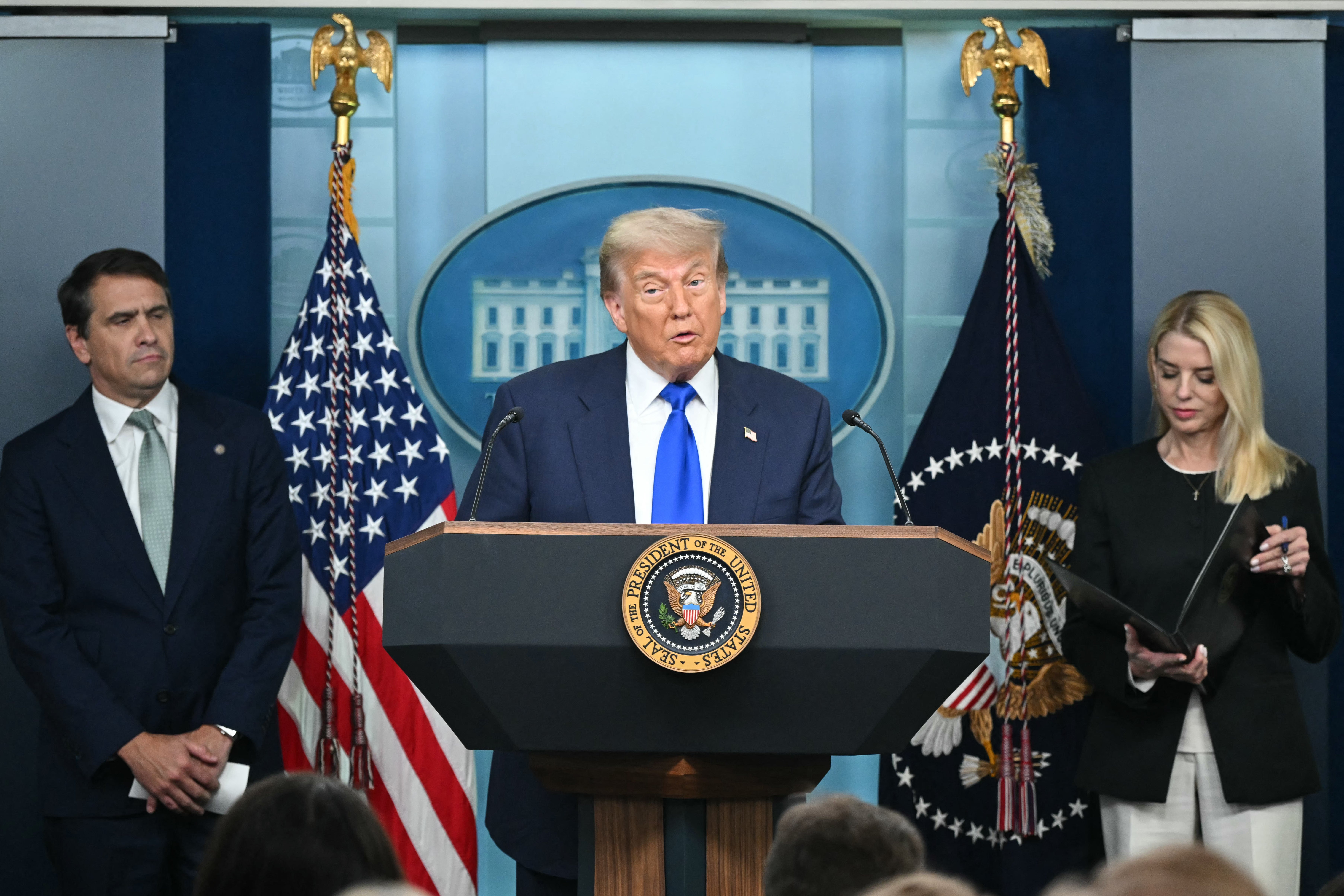 Trump speaks alongside Attorney General Pam Bondi (R) and Deputy Attorney General Todd Blanche during a news conference in the Brady Briefing Room of the White House Friday.