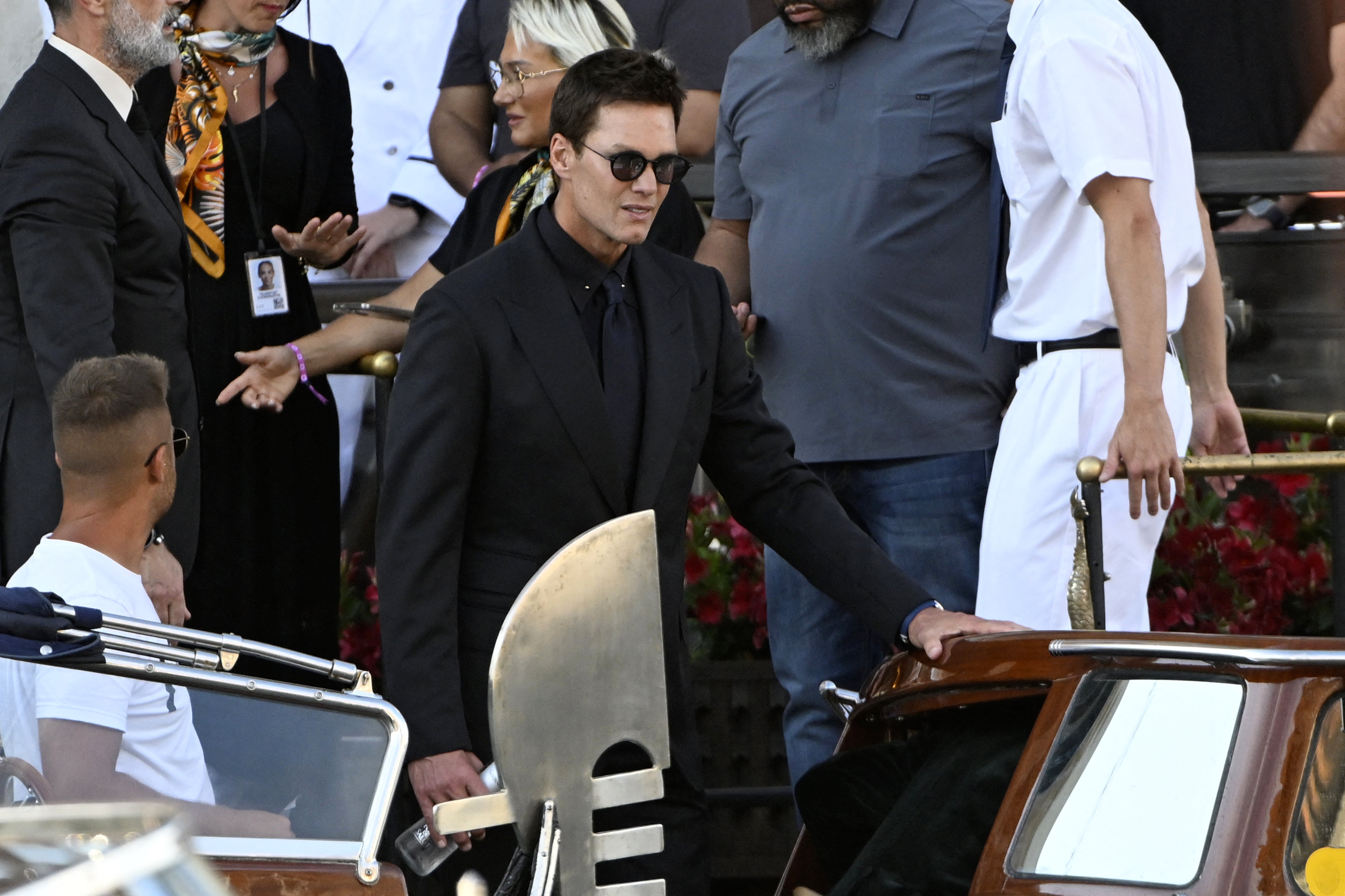 The former NFL quarterback looked more suited for a funeral instead of a wedding as he sported a black suit jacket with a navy blue tie