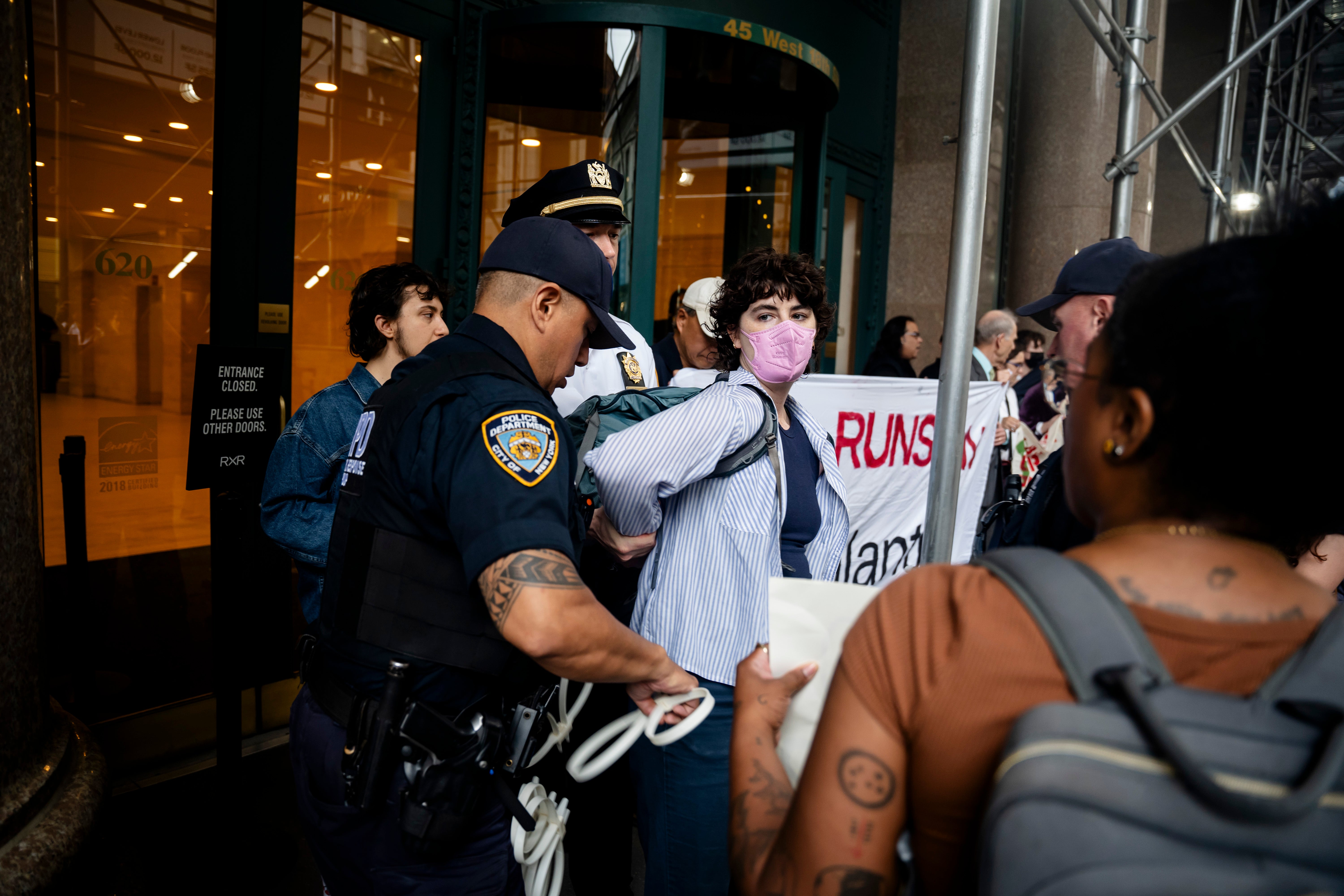 A protester is ziptied and detained outside Palantir's New York office on Thursday June 26, 2025