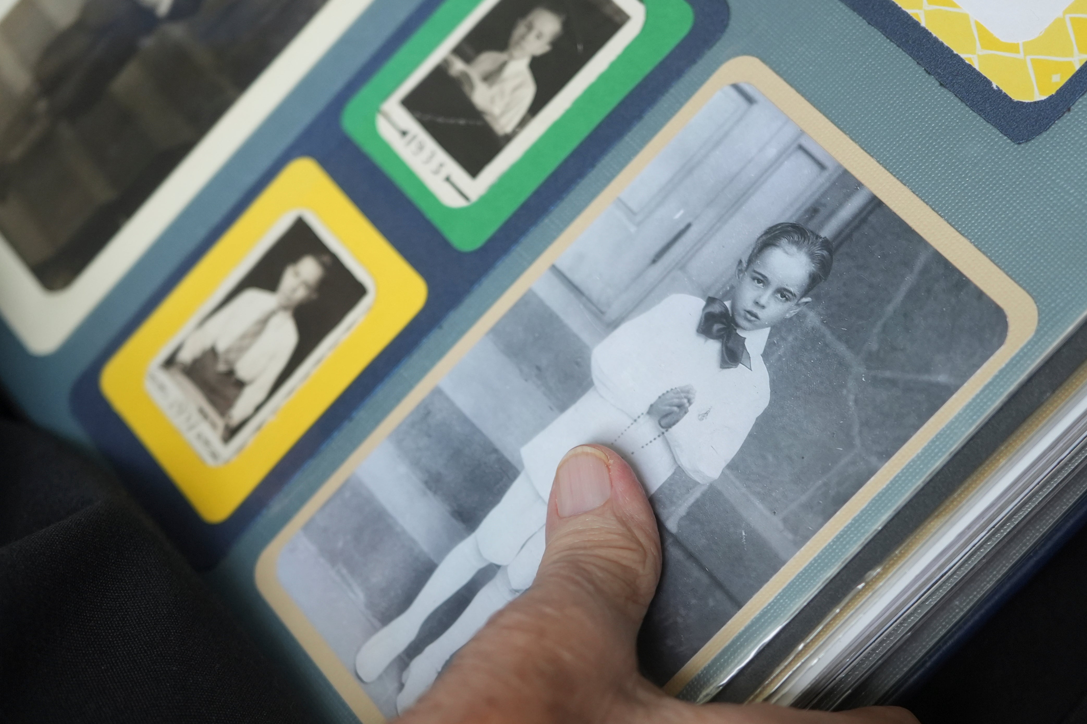 Rev. James Kelly points to a photo of himself at his first communion