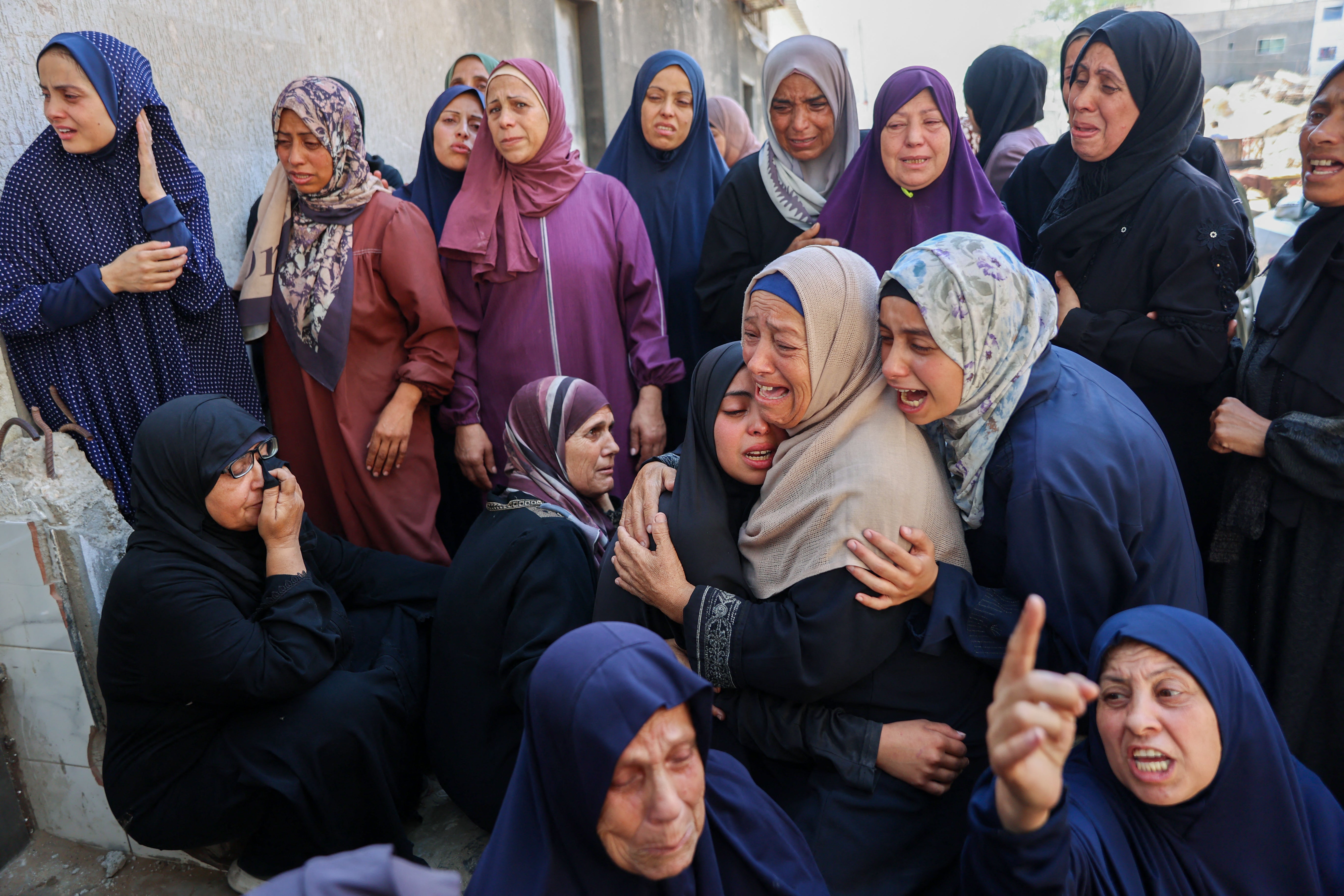 Palestinians mourn over the bodies of loved ones killed during overnight Israeli strikes
