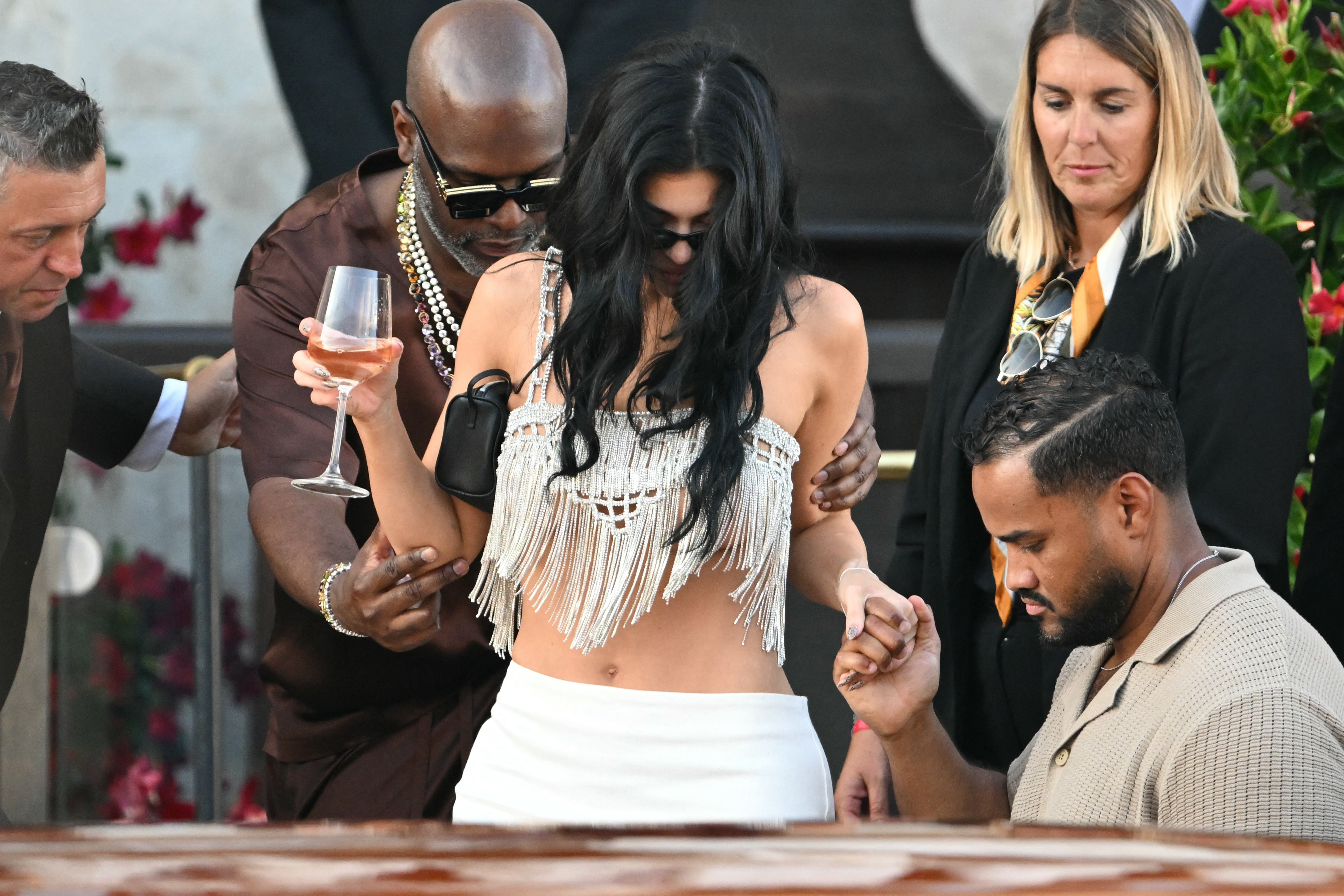On Saturday, Jenner looked like she was heading to Coachella instead of a wedding reception as she wore a white fringe top and white bottoms