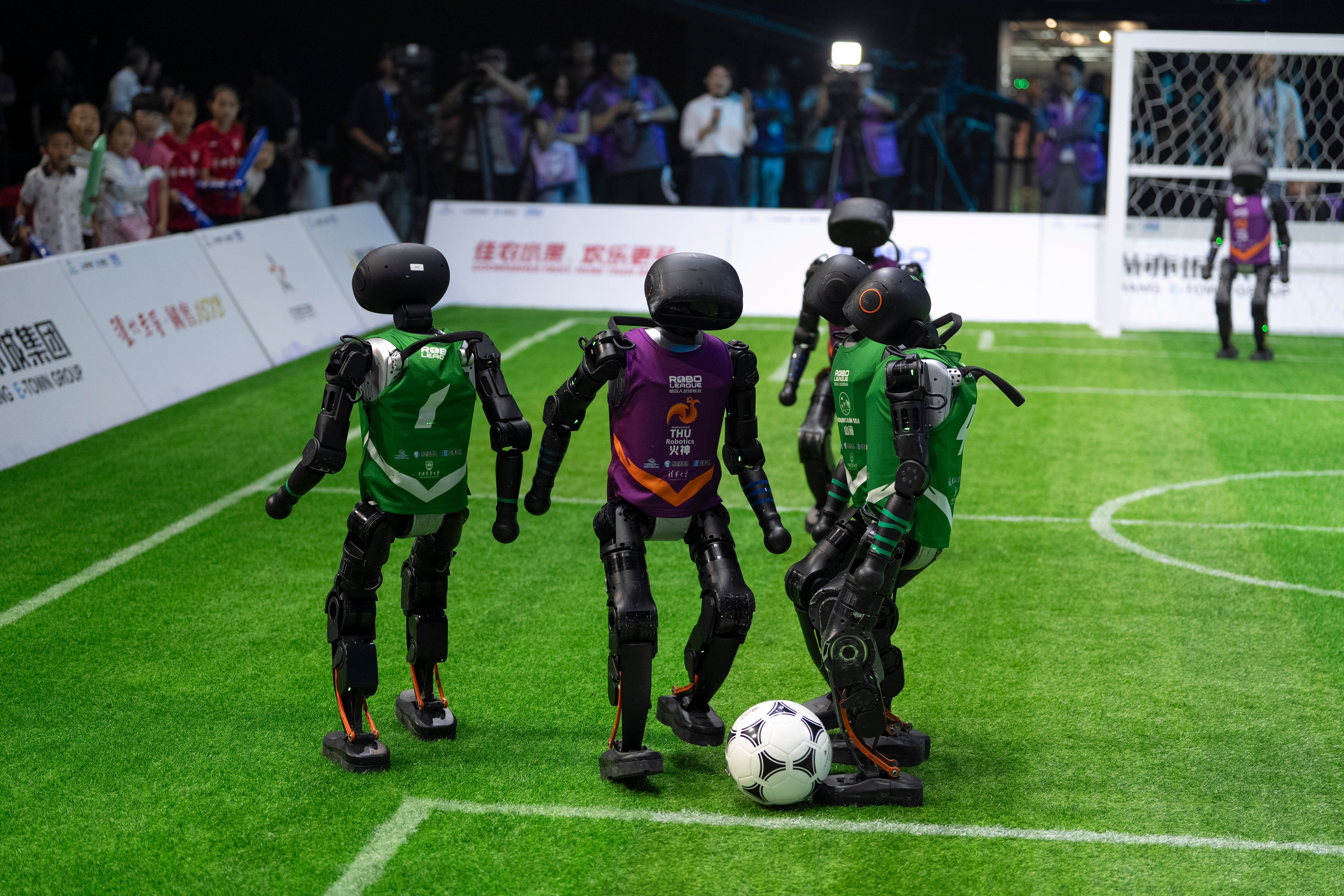 Robots cluster around the ball during the tournament