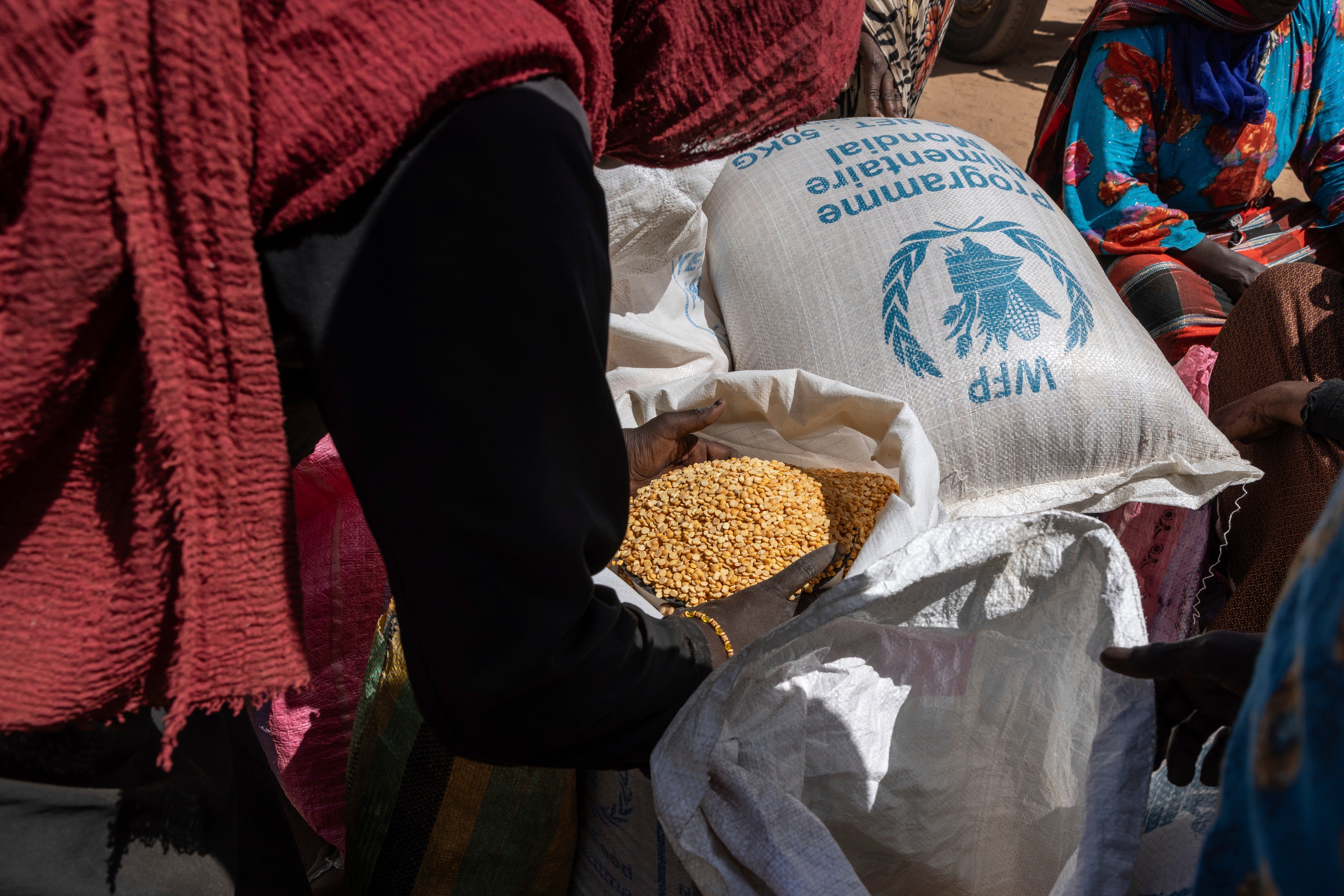 Refugees receive food supplies in the Adre, Chad, transit camp, into which many people from Sudan have fled