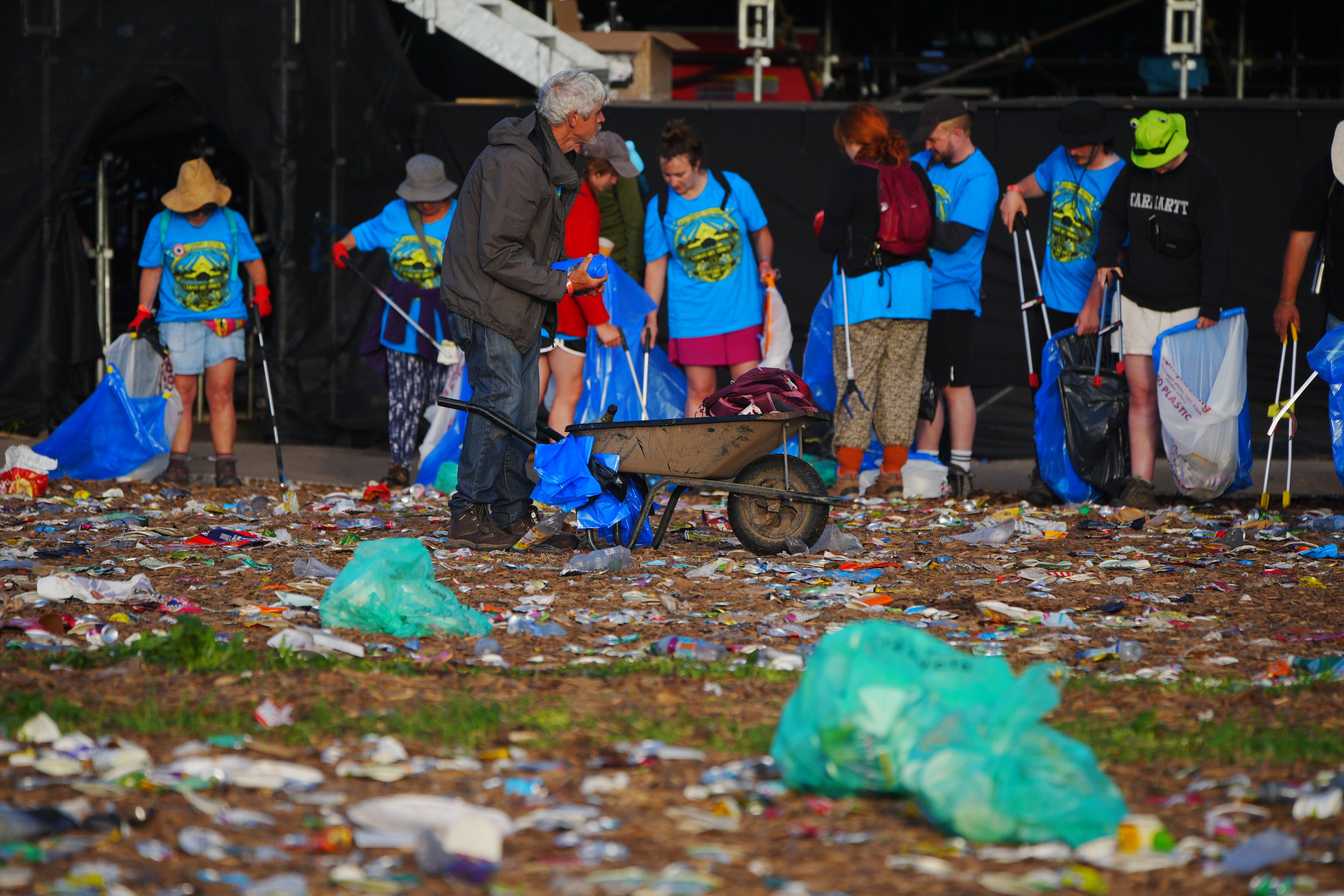 The clean-up operation begins in a field covered in litter at the end of the Glastonbury Festival (Ben Birchall/PA)