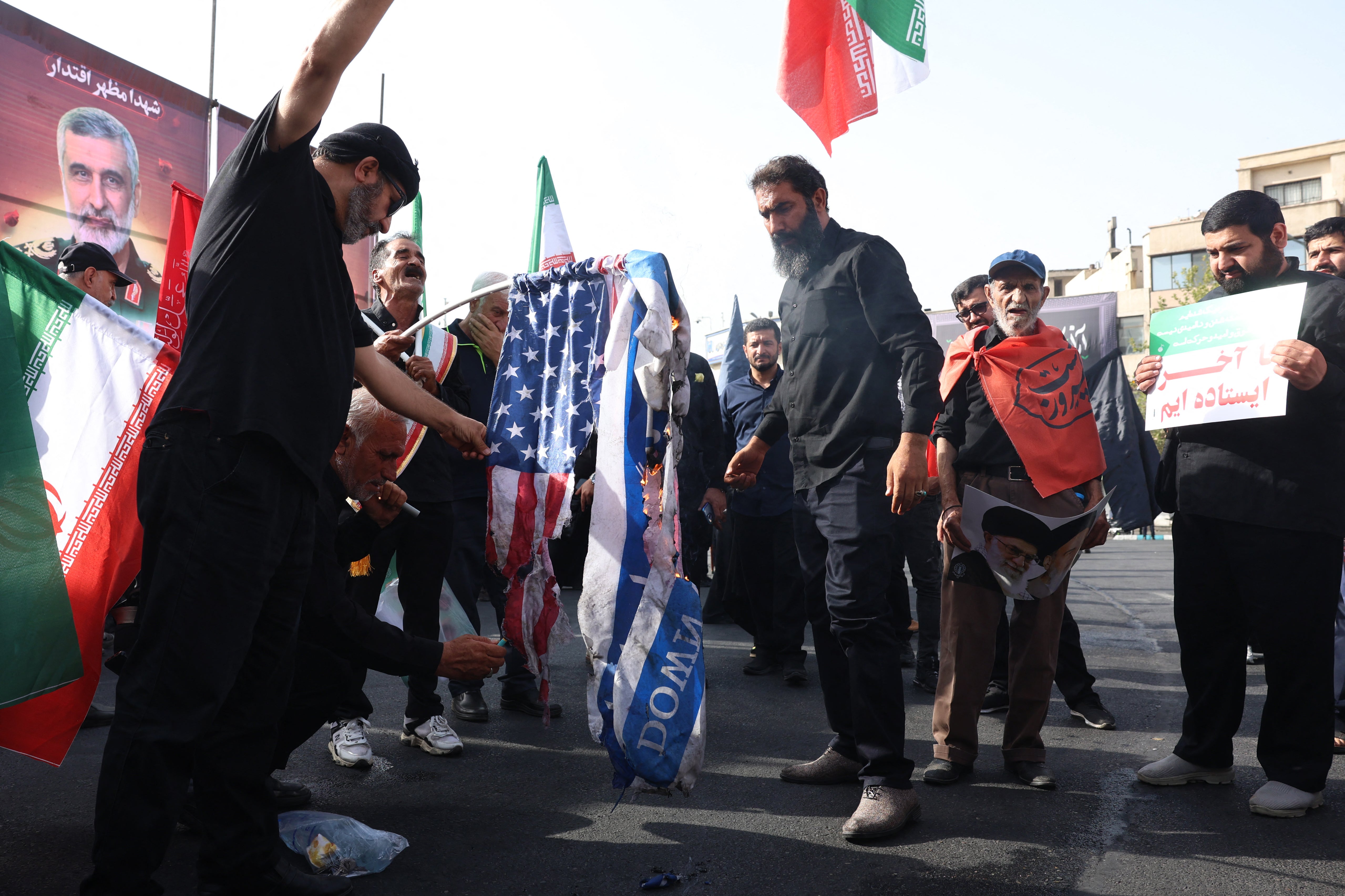 Iranians burn US and Israeli flags during a funeral ceremony in Tehran for Iranian IRGC generals and scientists who were killed in recent Israeli airstrikes