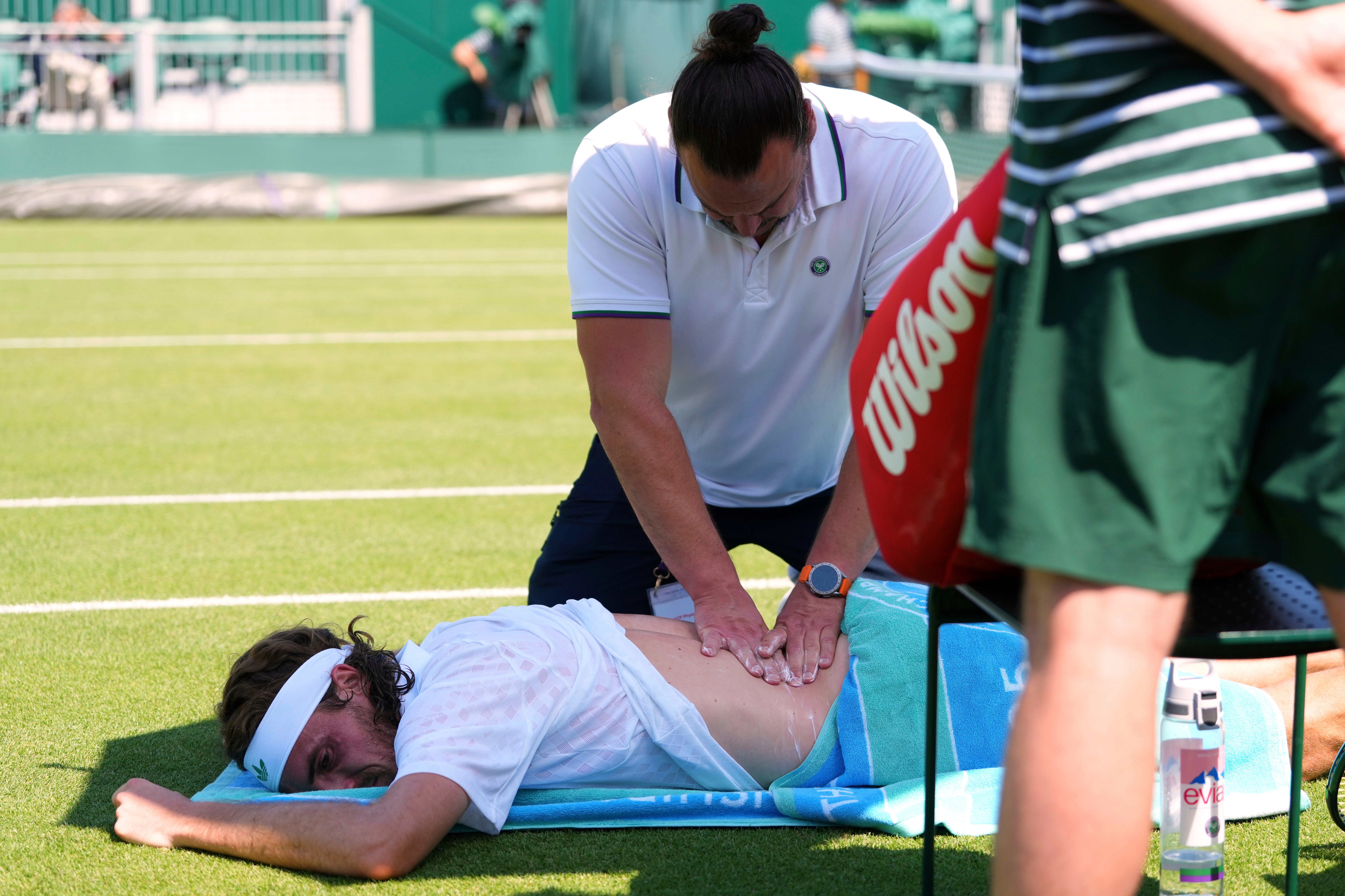 Stefanos Tsitsipas of Greece receives treatment during his first round men's single match against Valentine Royer