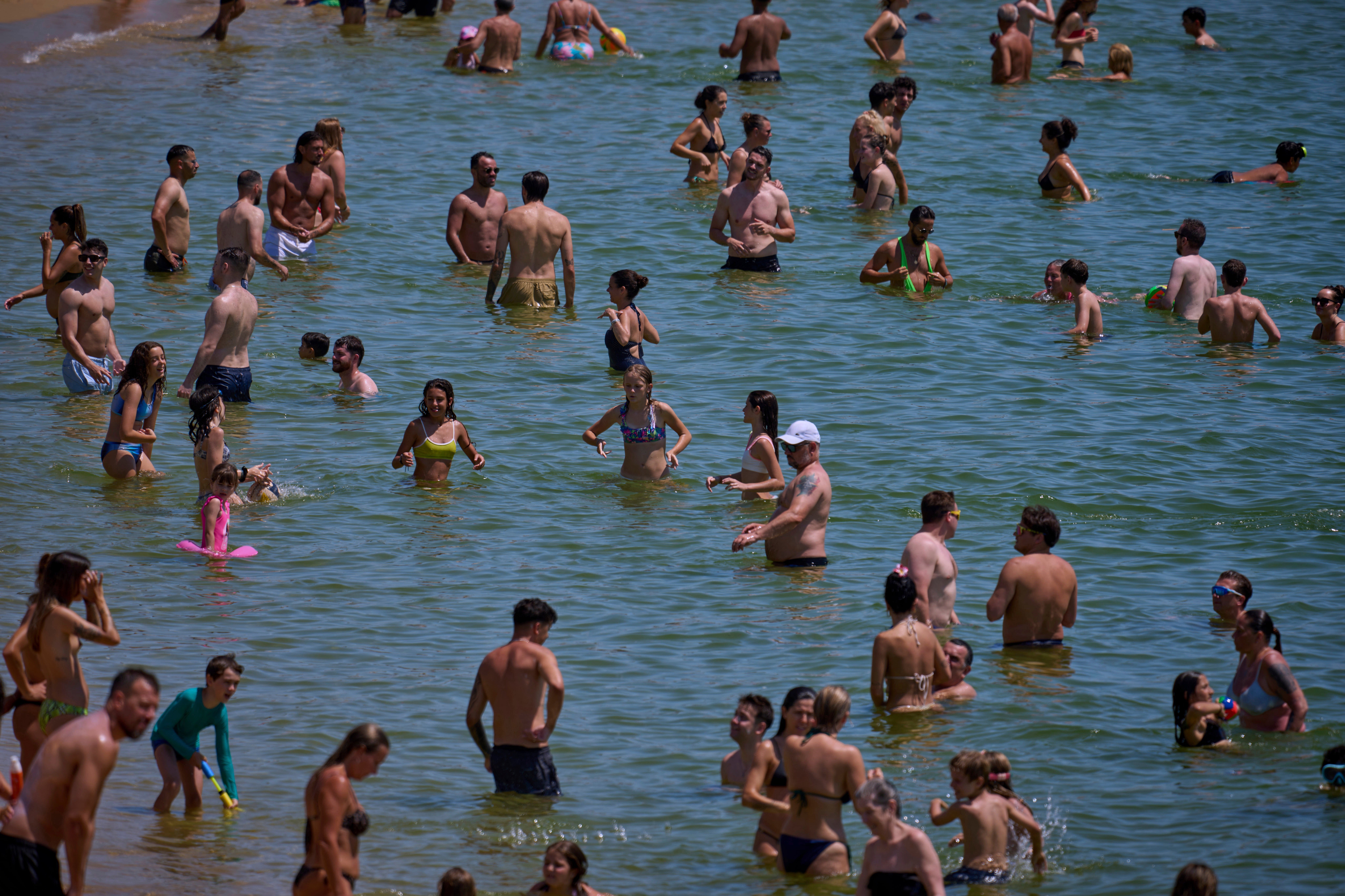 Swimmers cool off in the water at a beach on a hot day in Barcelona, Spain, Saturday, June 28, 2025. (AP Photo/Emilio Morenatti)