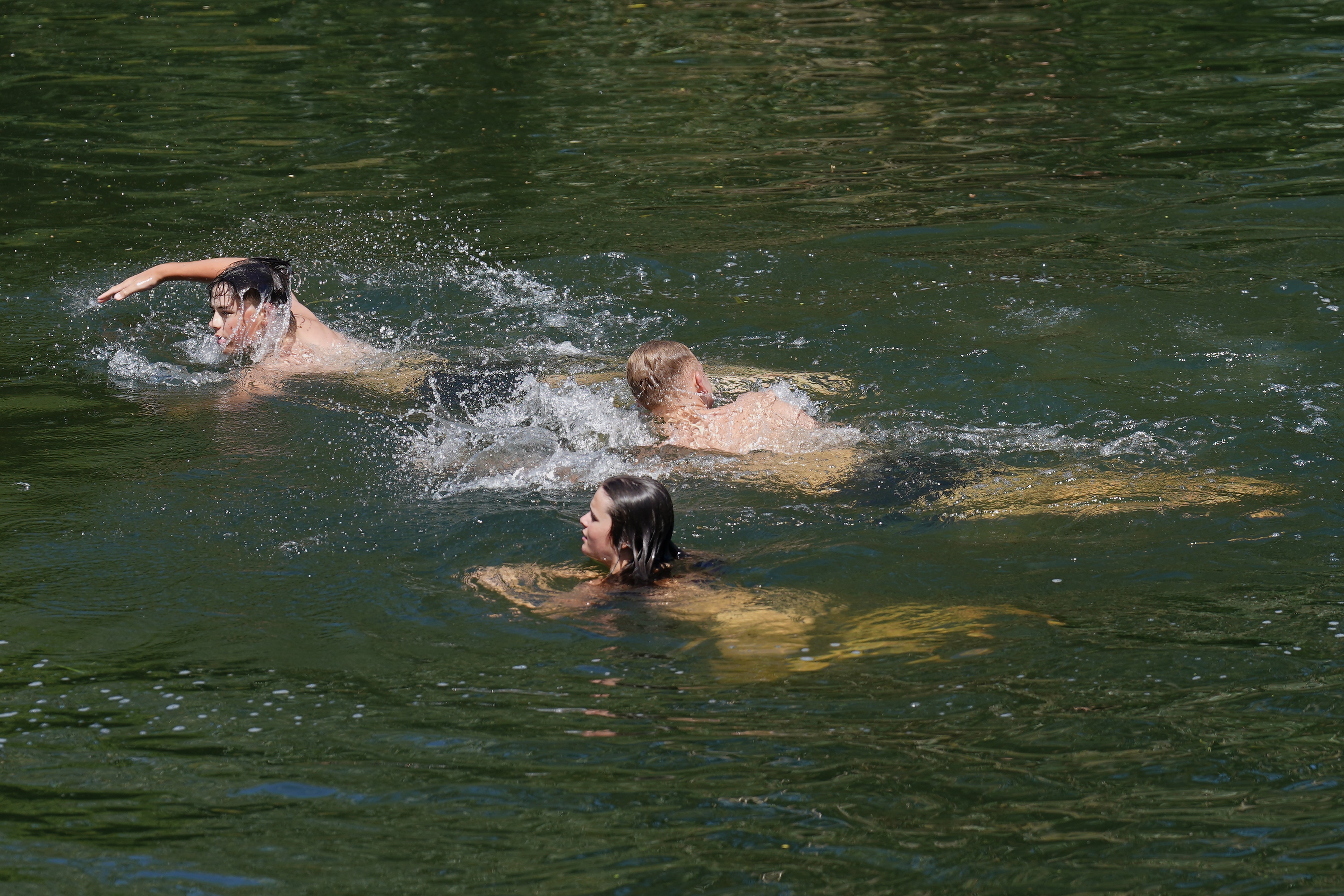 People swim in the River Nene to cool off in the heatwave