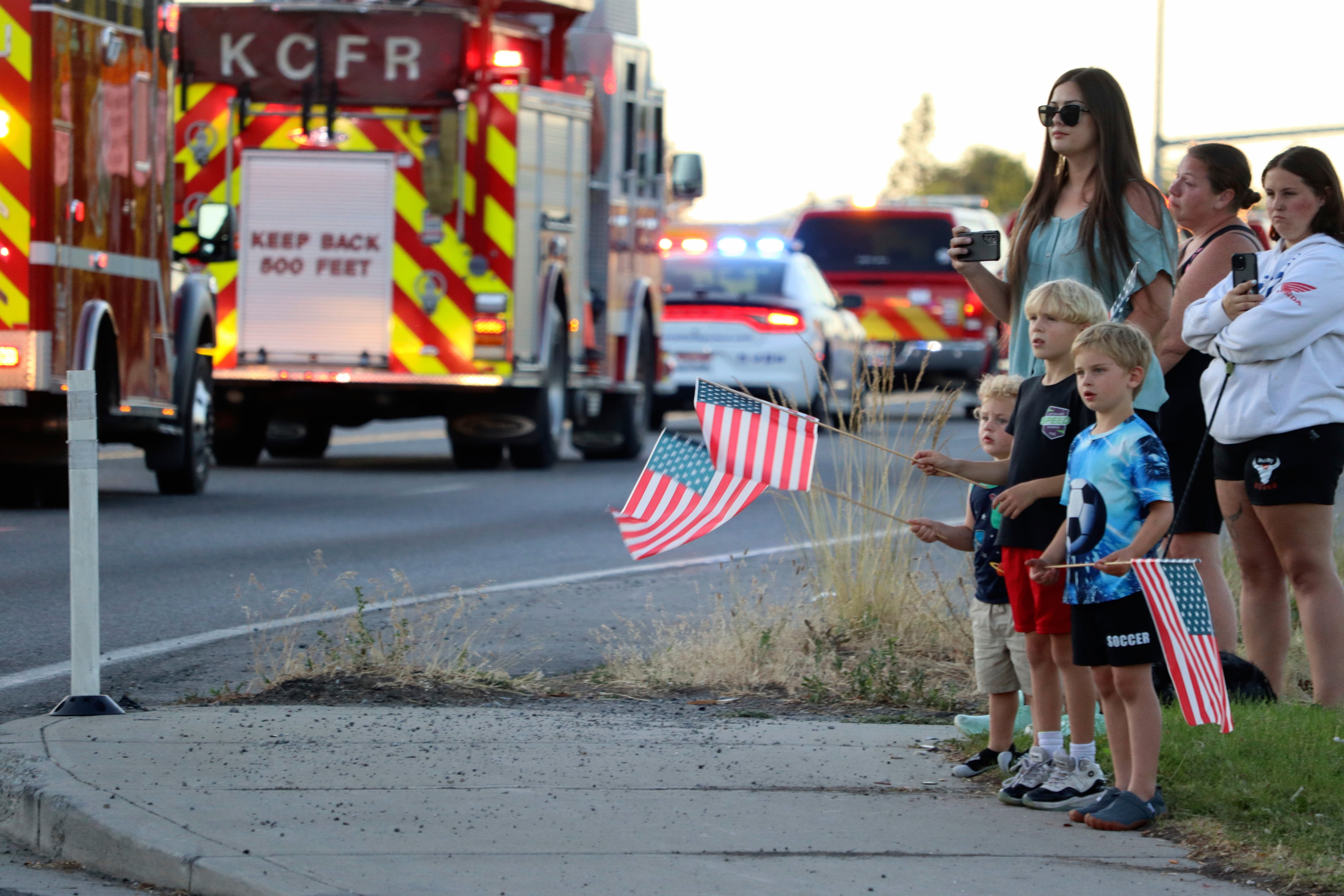 A procession from Kootenai Health headed to Spokane after firefighters were ambushed by sniper fire while responding to a blaze