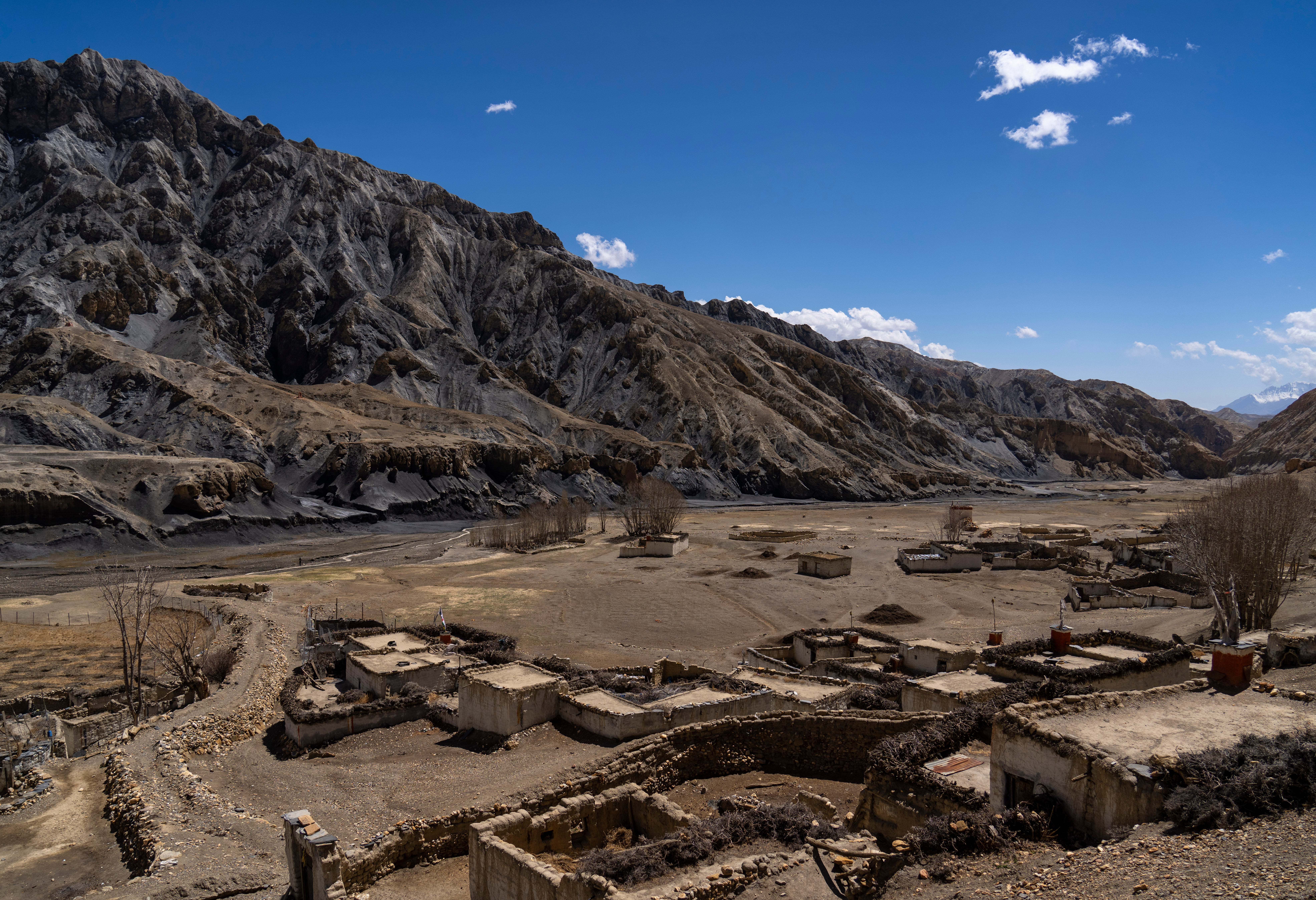 The abandoned village of Samjung, with ancient caves carved in the cliffs in the background, is seen in the Mustang region, 462 kilometers west of Kathmandu, Nepal, Friday, April 18, 2025. (AP Photo/Niranjan Shrestha)